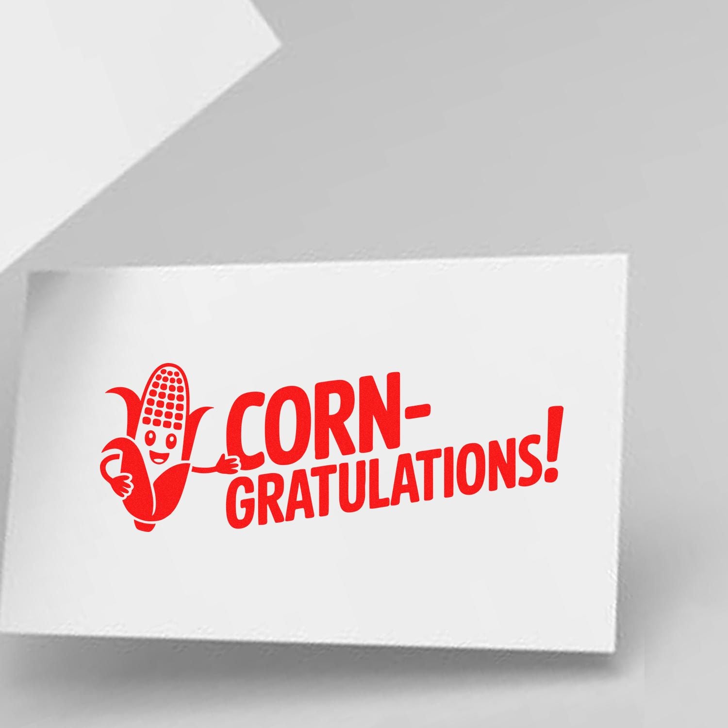 Corn-gratulations rubber stamp design for congratulatory cards, featuring a playful corn character in bold red.