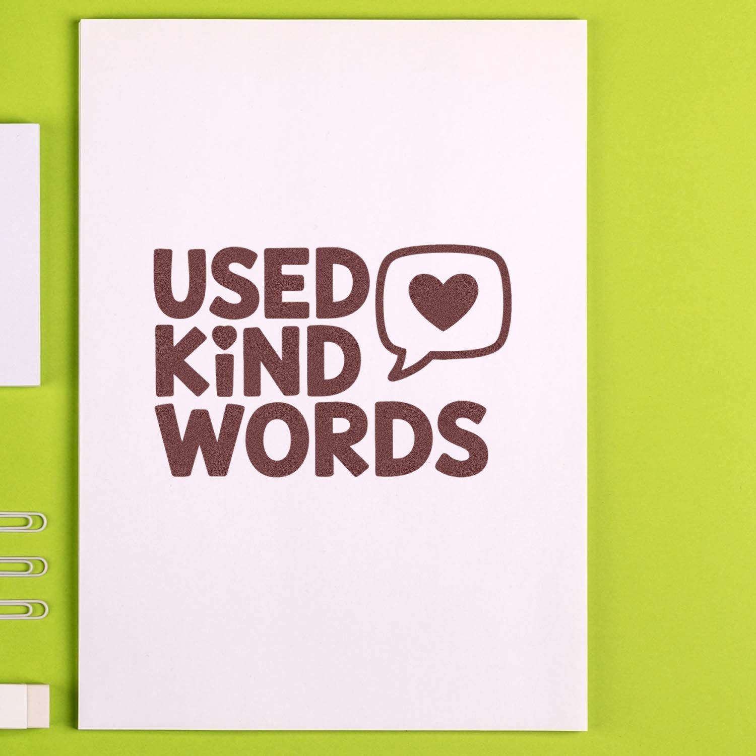 Used Kind Words rubber stamp impression with heart speech bubble on notebook, perfect for journaling and handmade packaging.