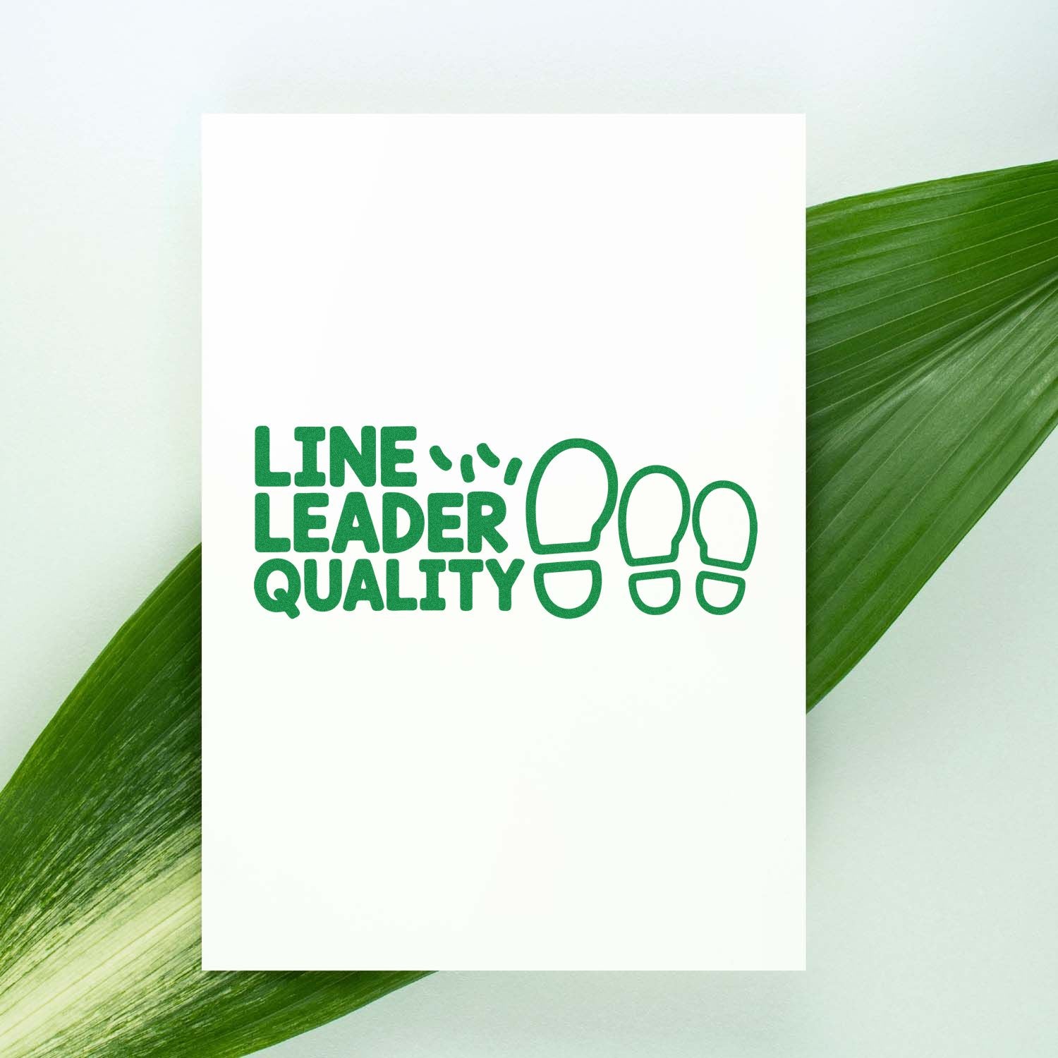 Line Leader Quality rubber stamp design with green footprints on white card, ideal for classroom reward or teacher stamping.
