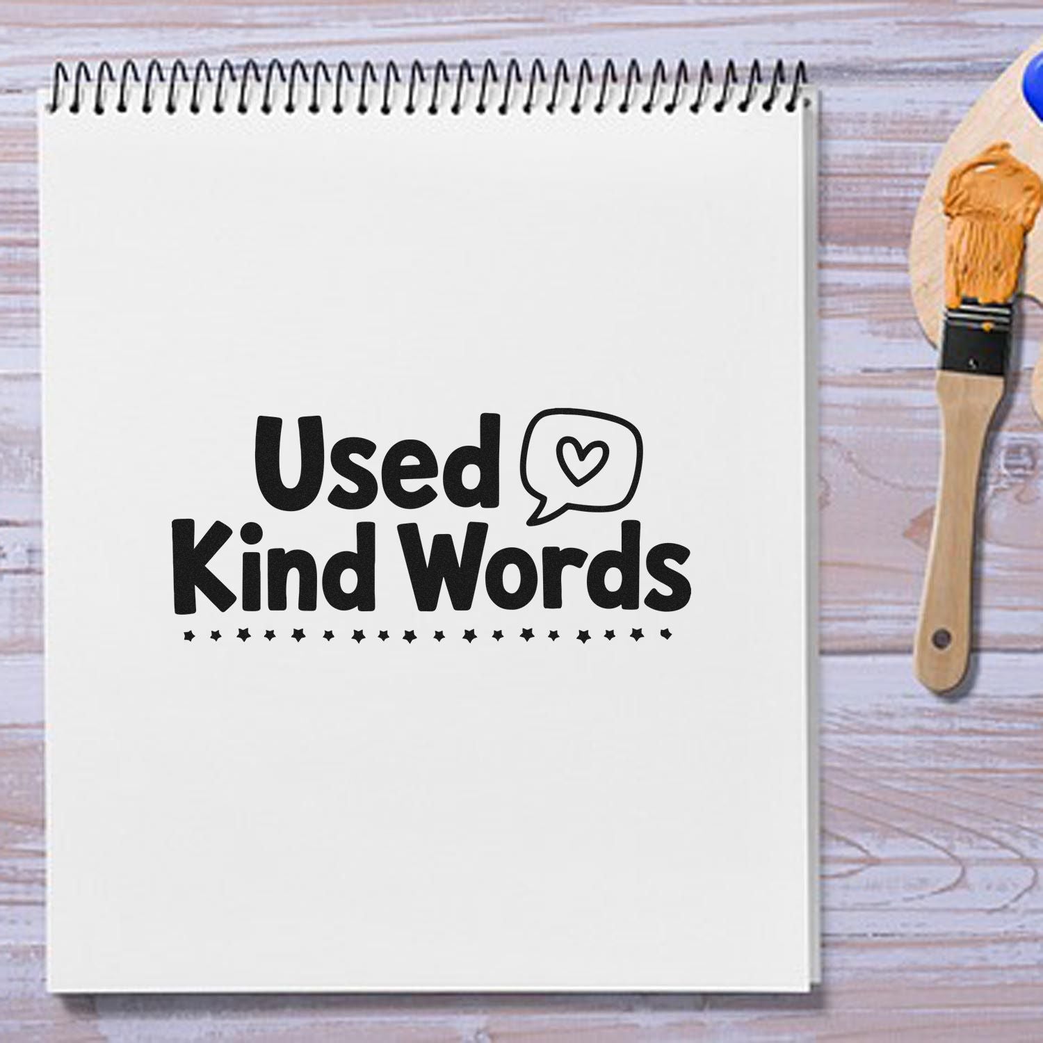 Used Kind Words rubber stamp design on a notebook, ideal for journaling, crafts, and handmade stationery projects.