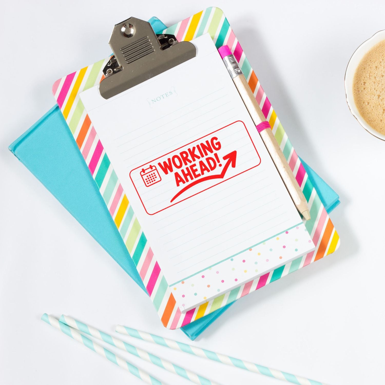 Working Ahead rubber stamp on clipboard with planner supplies, ideal for office productivity and project management reminders.