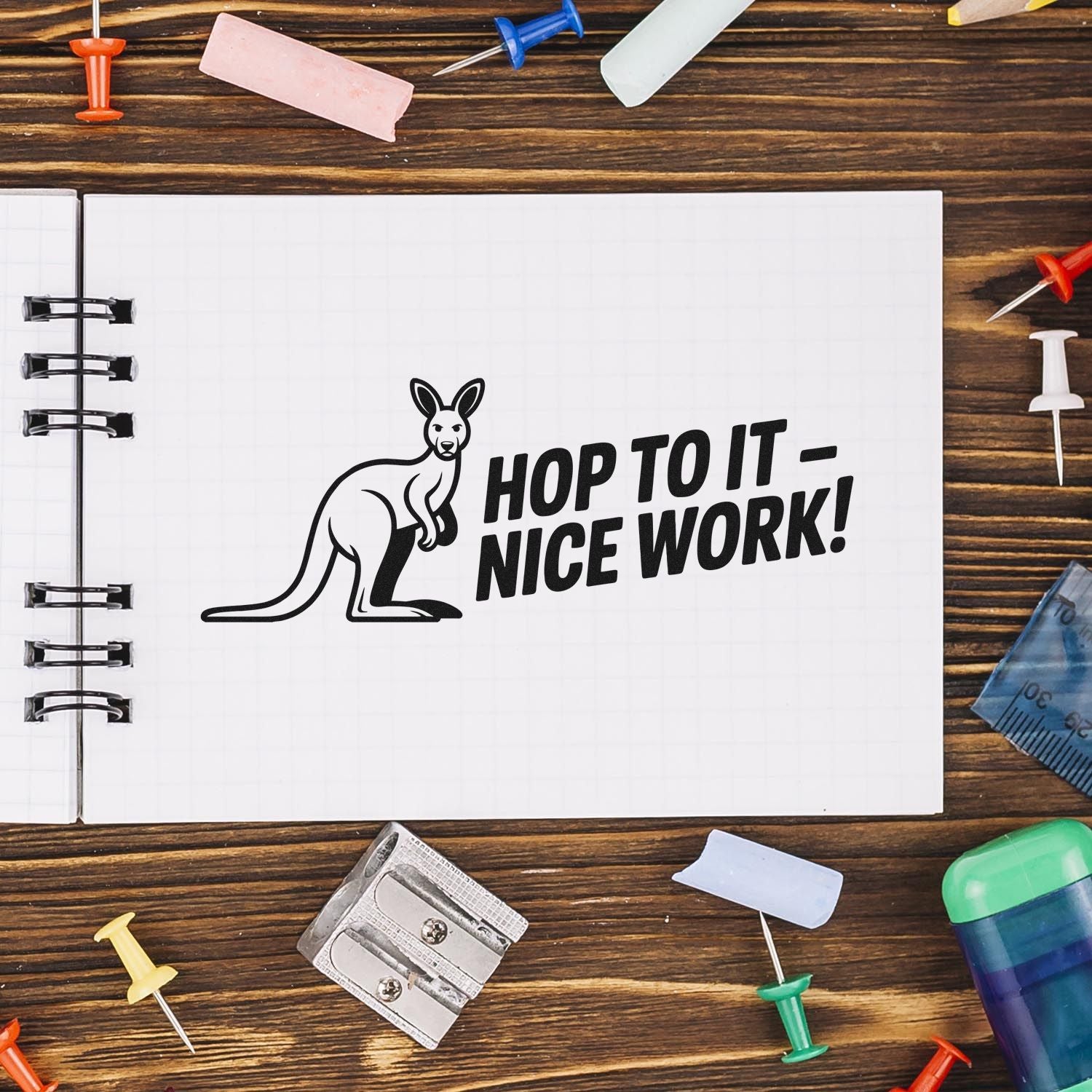Motivational kangaroo rubber stamp with Hop to it  nice work! on a notebook, ideal for teacher and office rewards.