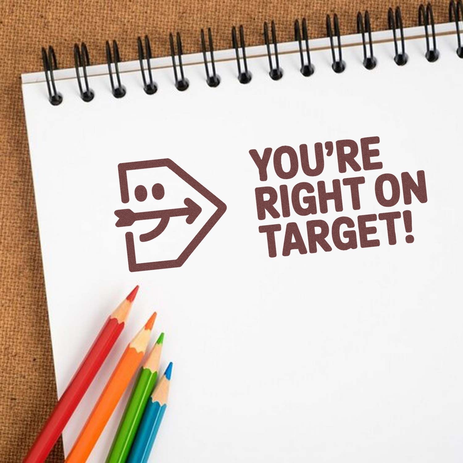 Rubber stamp impression reading Youre right on target! on notebook paper, ideal for teacher grading and office rewards.