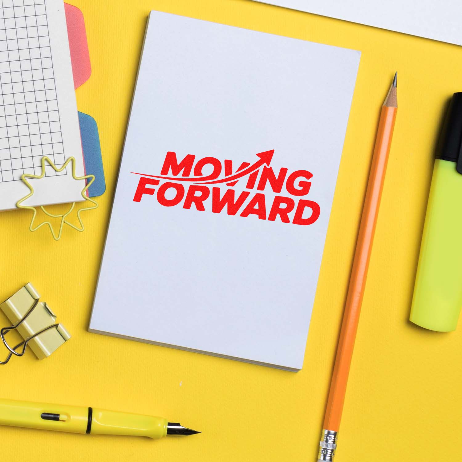 Motivational moving forward rubber stamp on notebook with stationery, ideal for planner, office, and business branding.