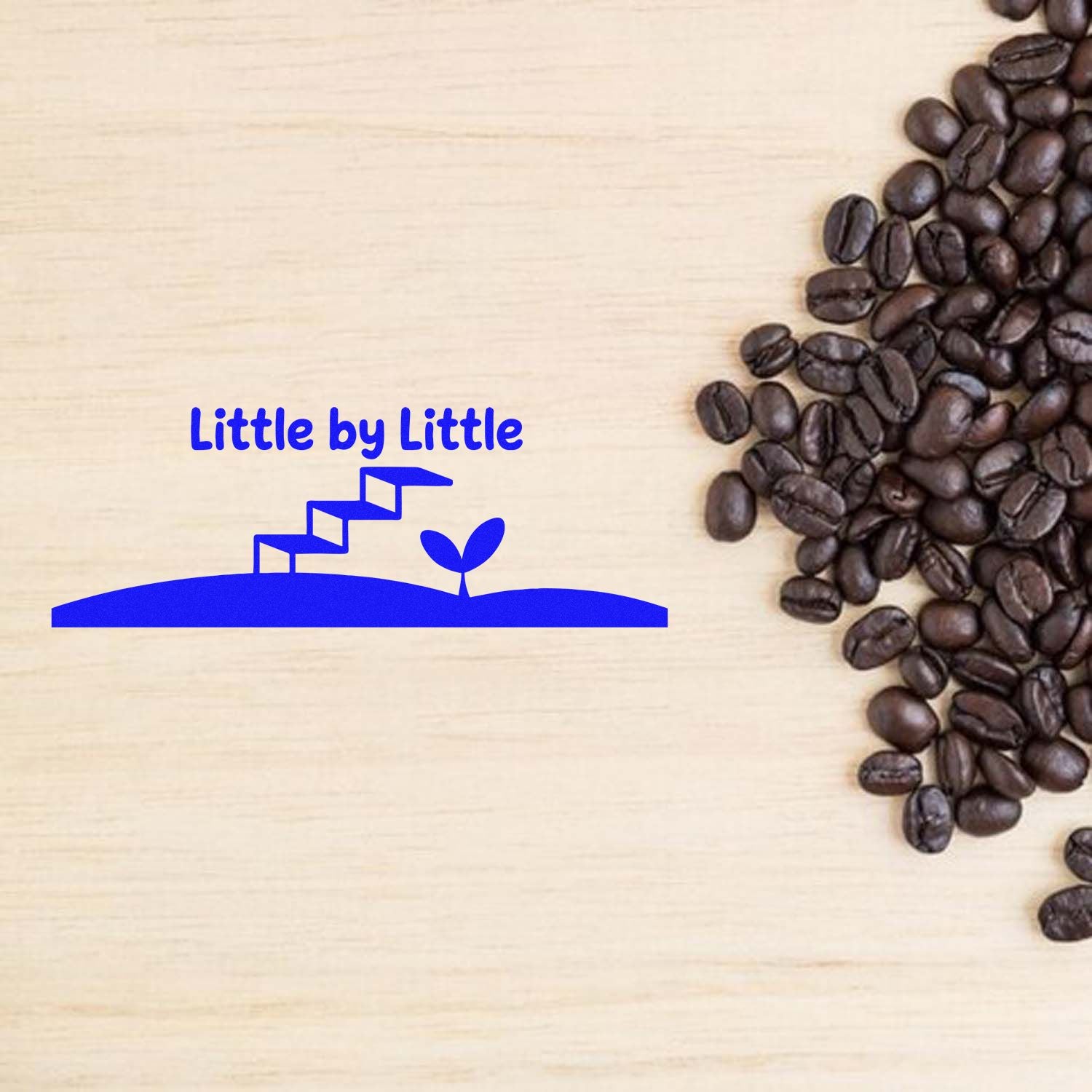 Little by Little motivational rubber stamp design with staircase sprout, shown beside coffee beans on a wood background