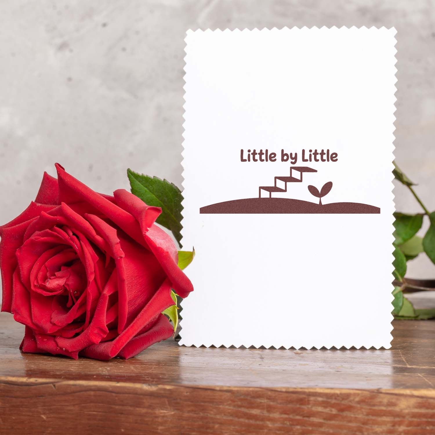 Little by Little rubber stamp design on a greeting card, featuring stairs and a sprout to symbolize growth and progress.