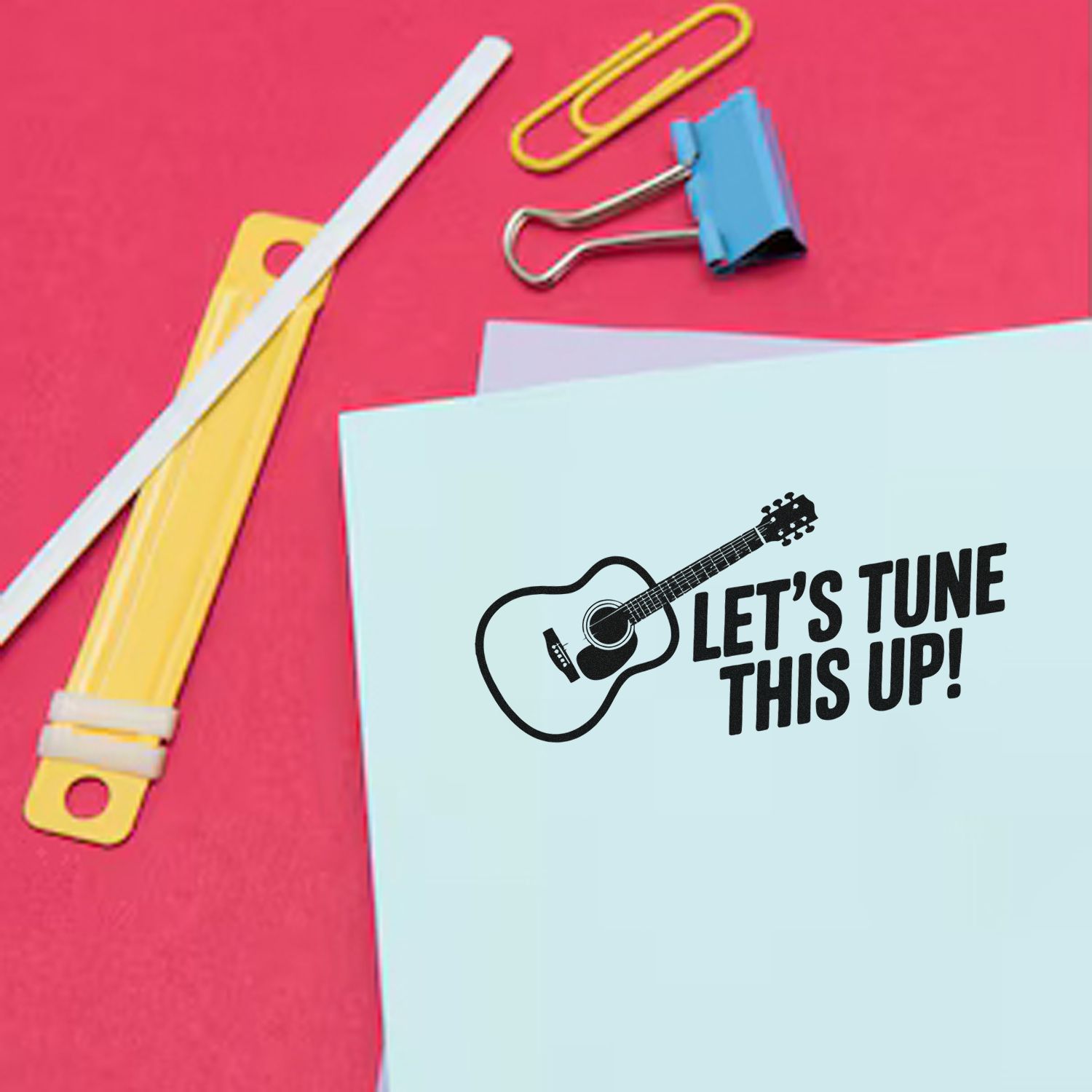 Custom rubber stamp with guitar design and Lets Tune This Up! text on paper, ideal for music-themed branding.