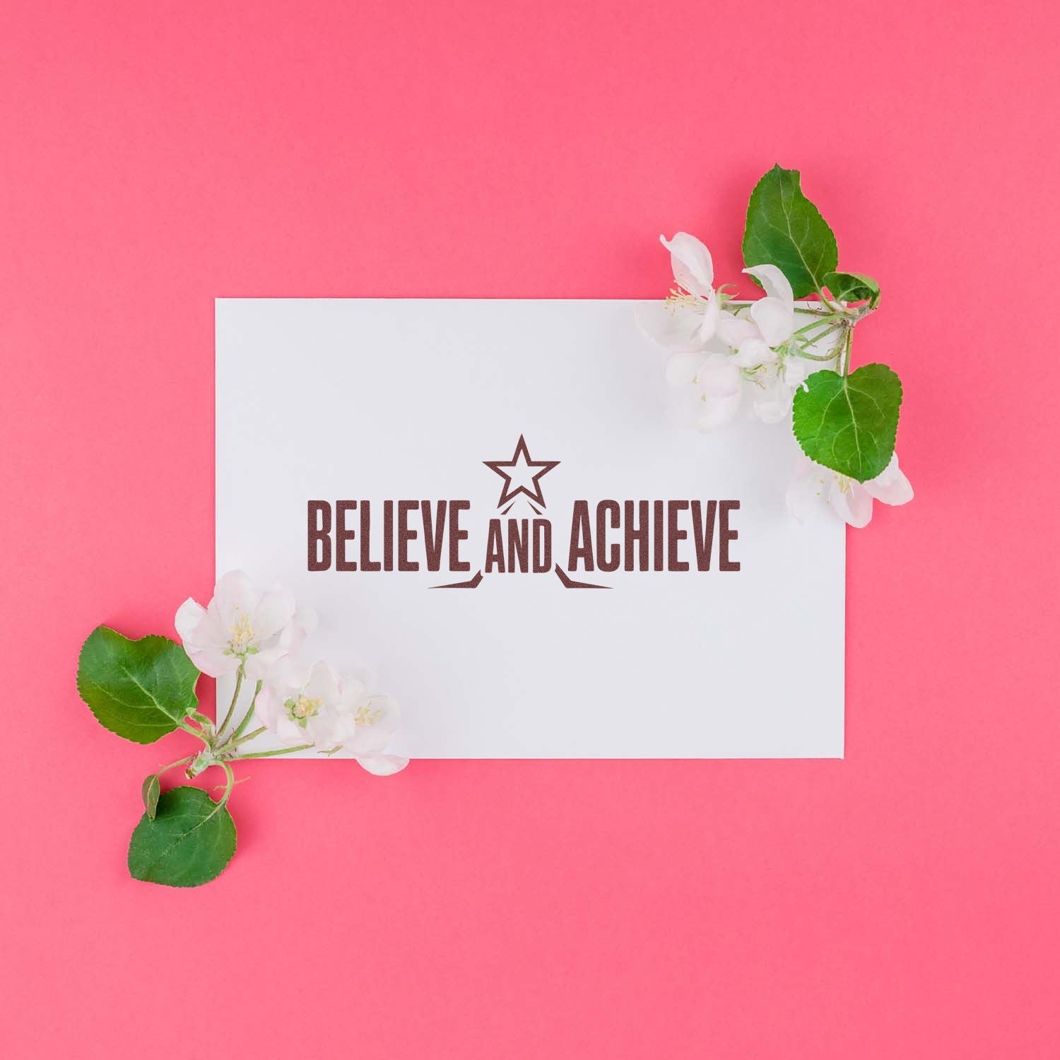 Motivational Believe and Achieve rubber stamp on white card with flowers, ideal for custom business branding.