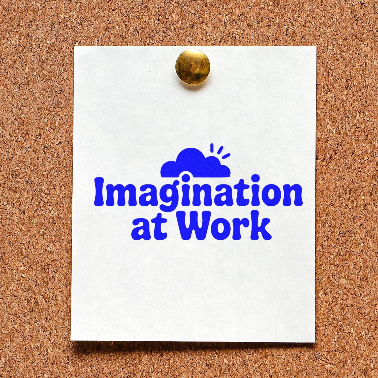 Imagination at Work rubber stamp design in blue on pinned white paper, displayed on a corkboard.