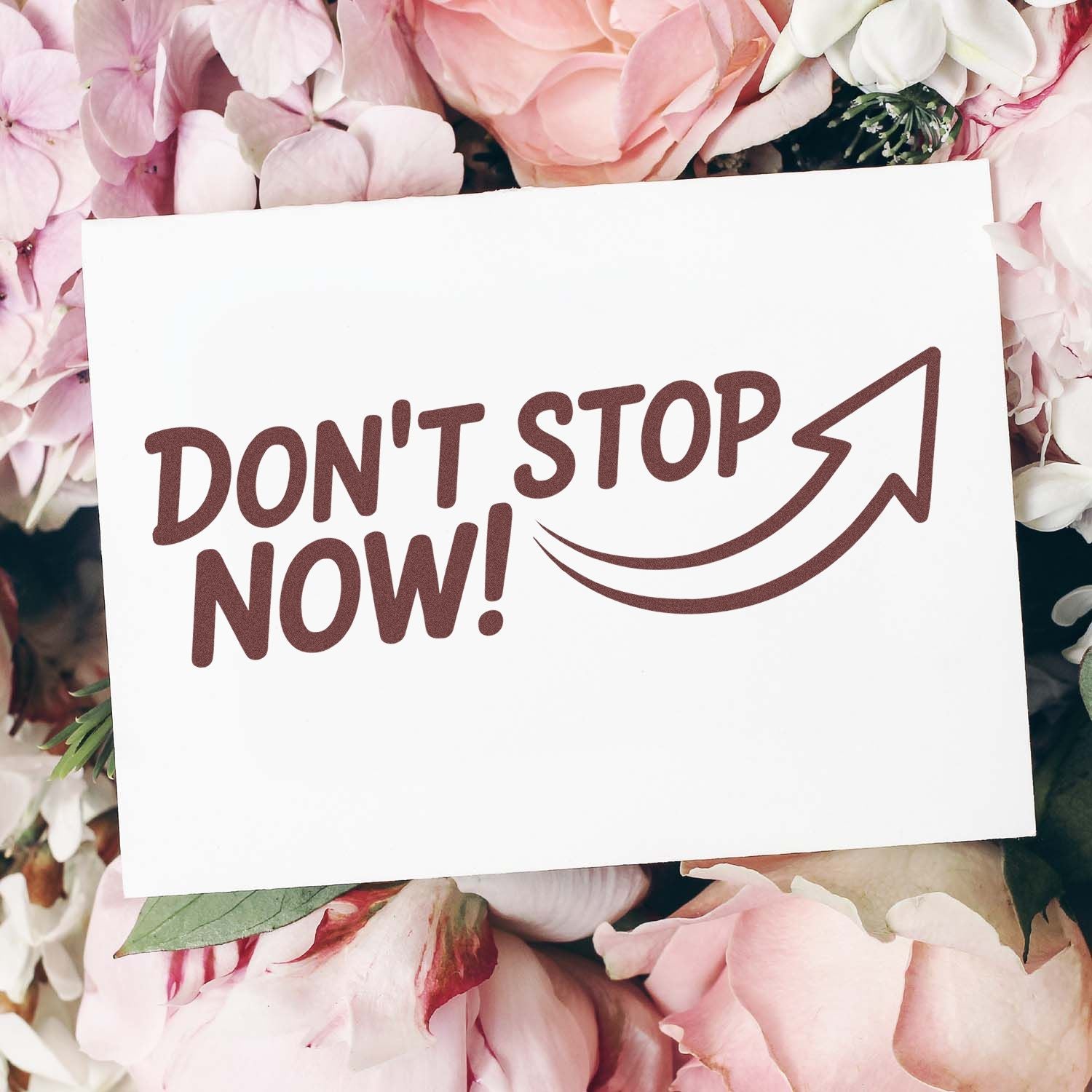 Don't Stop Now rubber stamp design with arrow on floral card mockup for motivational crafting and handmade business branding.