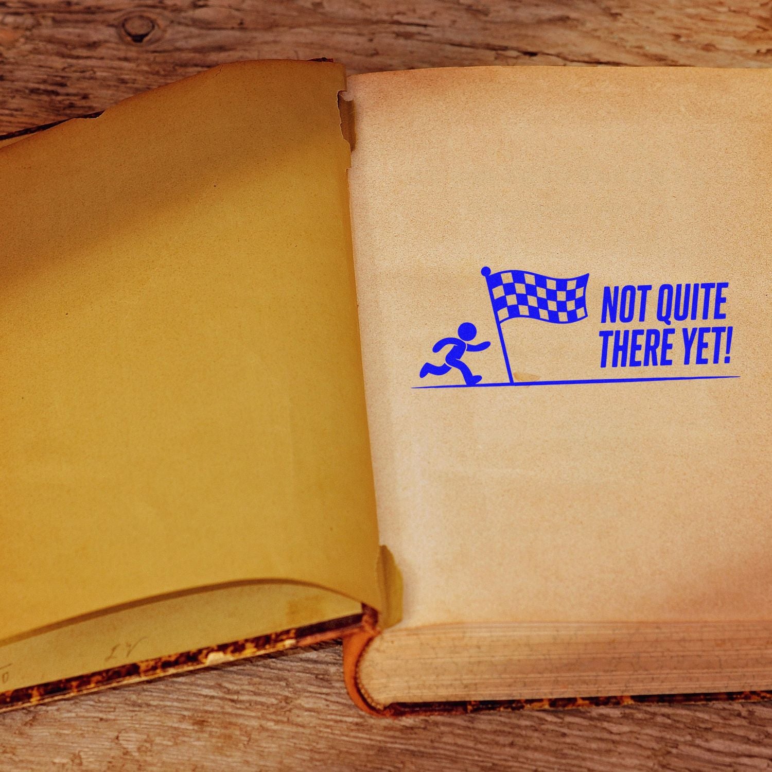 Not Quite There Yet rubber stamp on open book, ideal for motivational journaling, progress tracking, and encouragement.