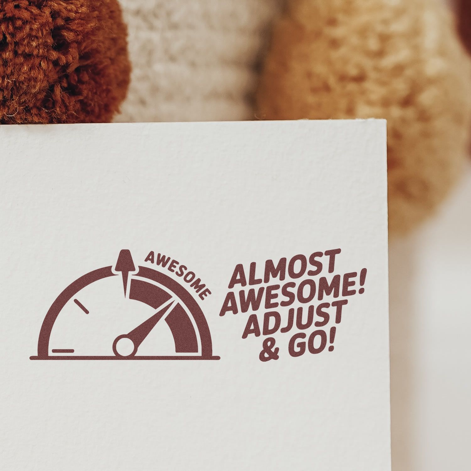 Custom rubber stamp imprint reading Almost Awesome! Adjust & Go! with speedometer design on white paper.