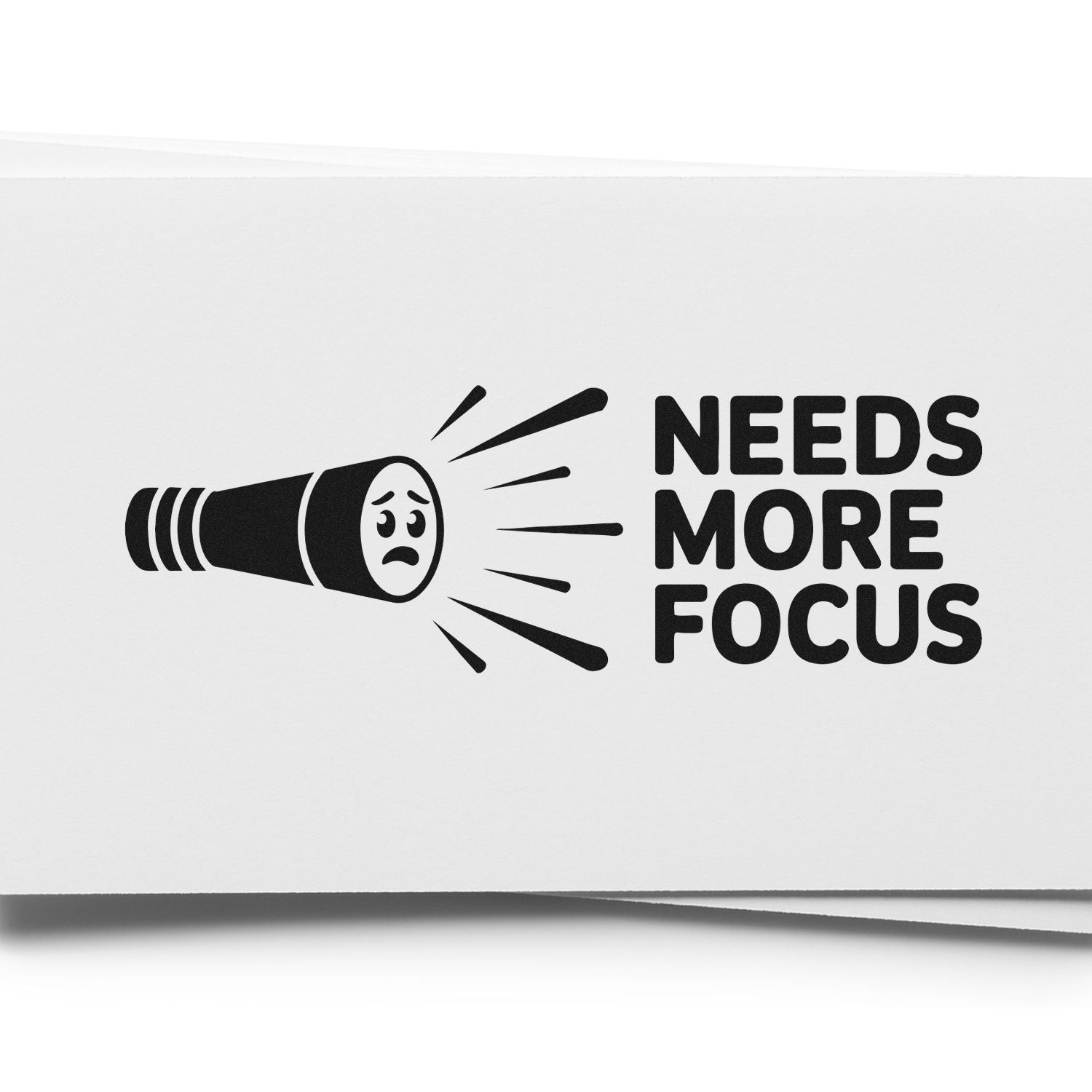 Needs More Focus rubber stamp design with flashlight graphic, ideal for funny office, teacher, or feedback stamping.
