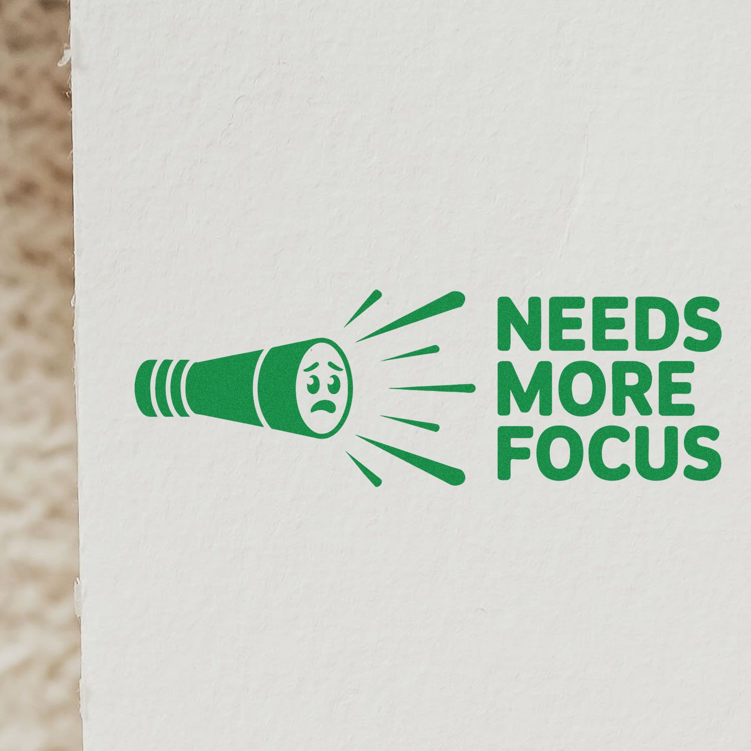 Green rubber stamp design with flashlight icon and Needs More Focus text for office, teacher, or feedback use.
