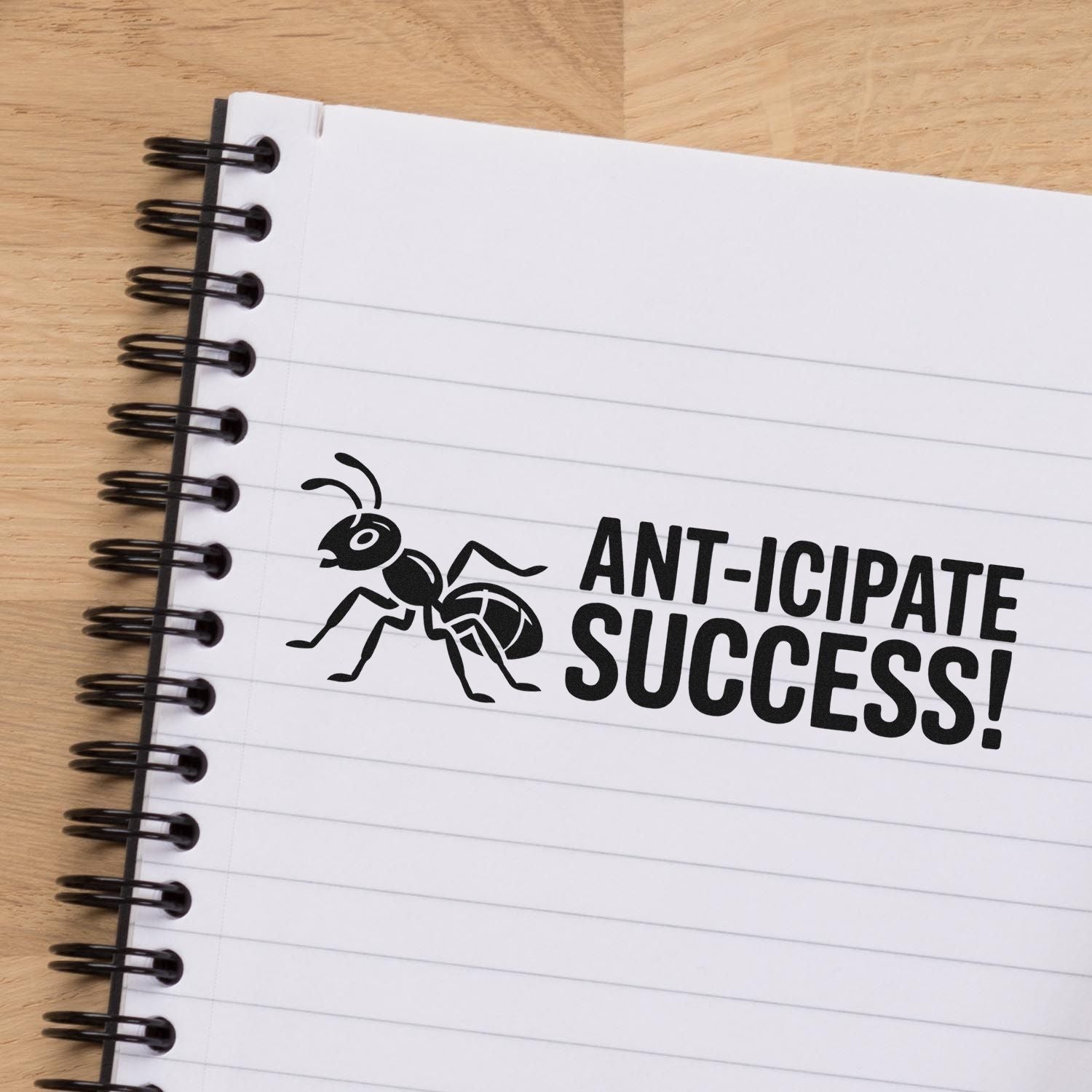 Ant-icipate Success! ant-themed rubber stamp on notebook page, a motivational office stamp design for planners, teachers, and business use.