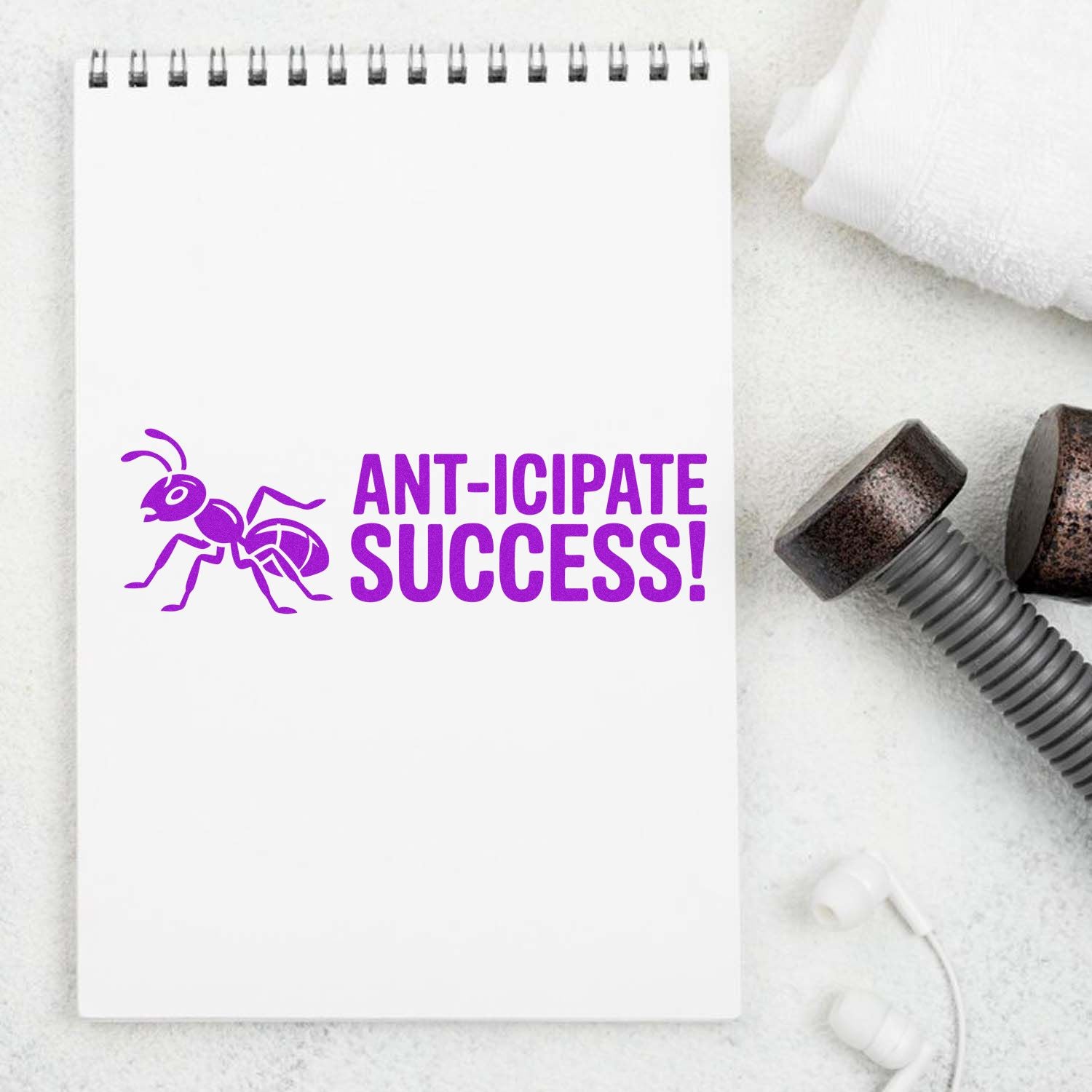 Anticipate Success! Purple ant rubber stamp design on spiral notebook, shown with stamp tools.