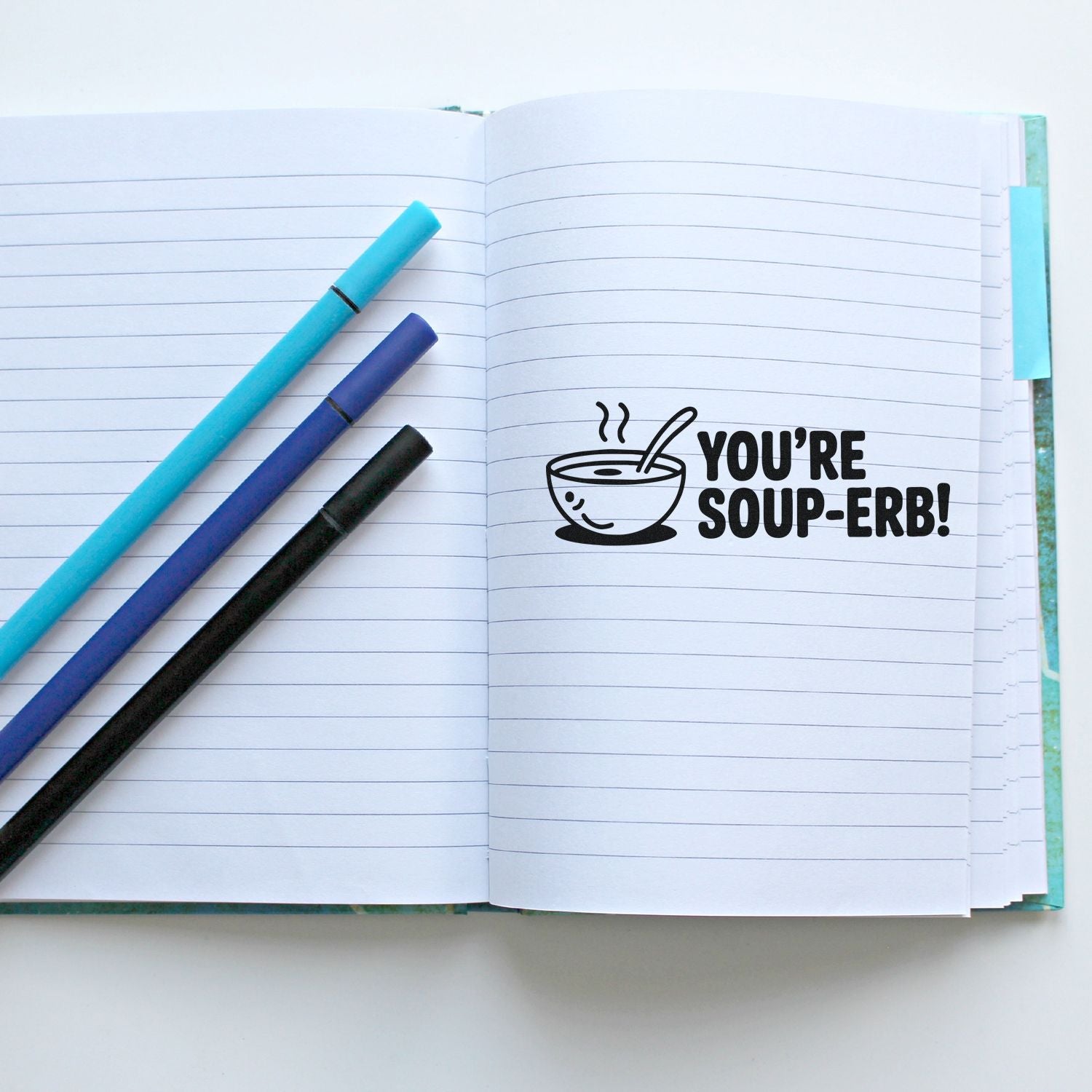 Funny Youre Soup-erb! rubber stamp on a lined notebook with pens, ideal for handmade cards, journaling, and gift tags.