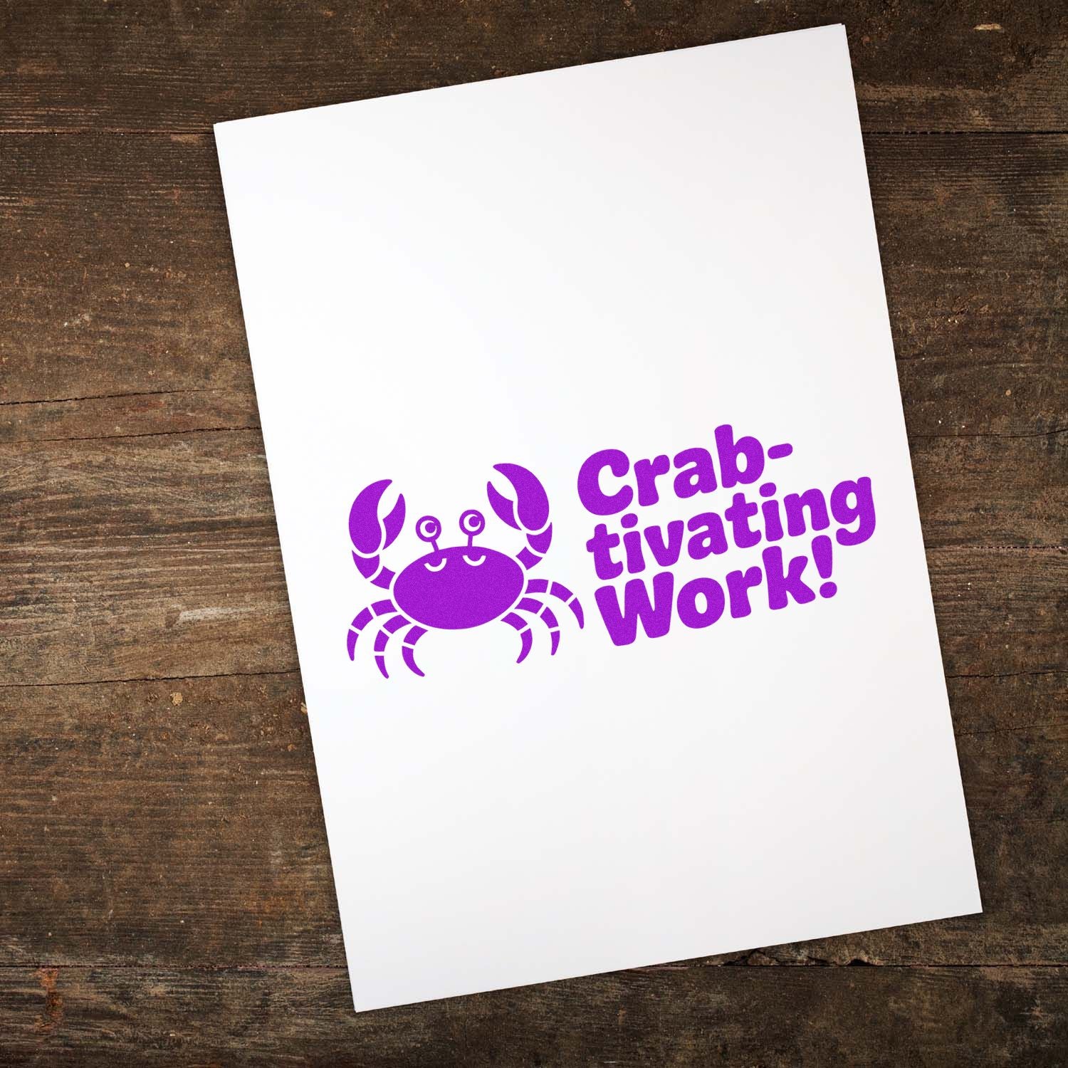 Purple crab rubber stamp reading Crab-tivating Work! on a white card, ideal for fun congratulatory office stamping.