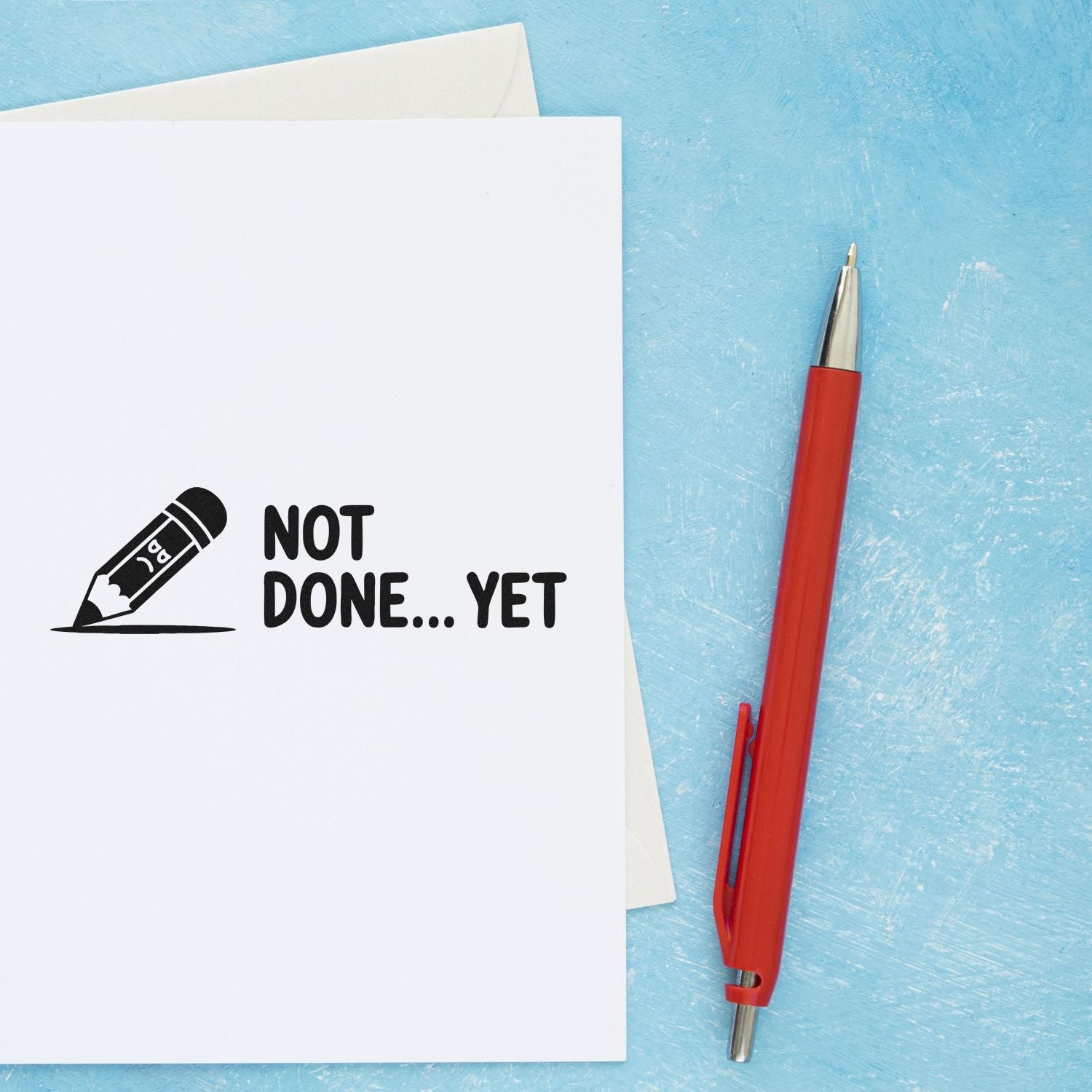 Not Done Yet rubber stamp on white paper beside a red pen, ideal for marking unfinished assignments or projects.