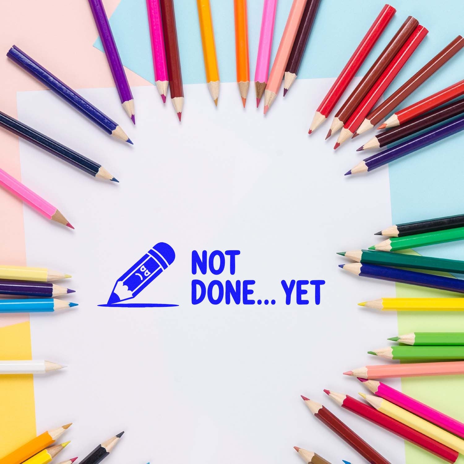 Not Done Yet rubber stamp with pencil icon on white paper, surrounded by colored pencils for school, craft, and office use.