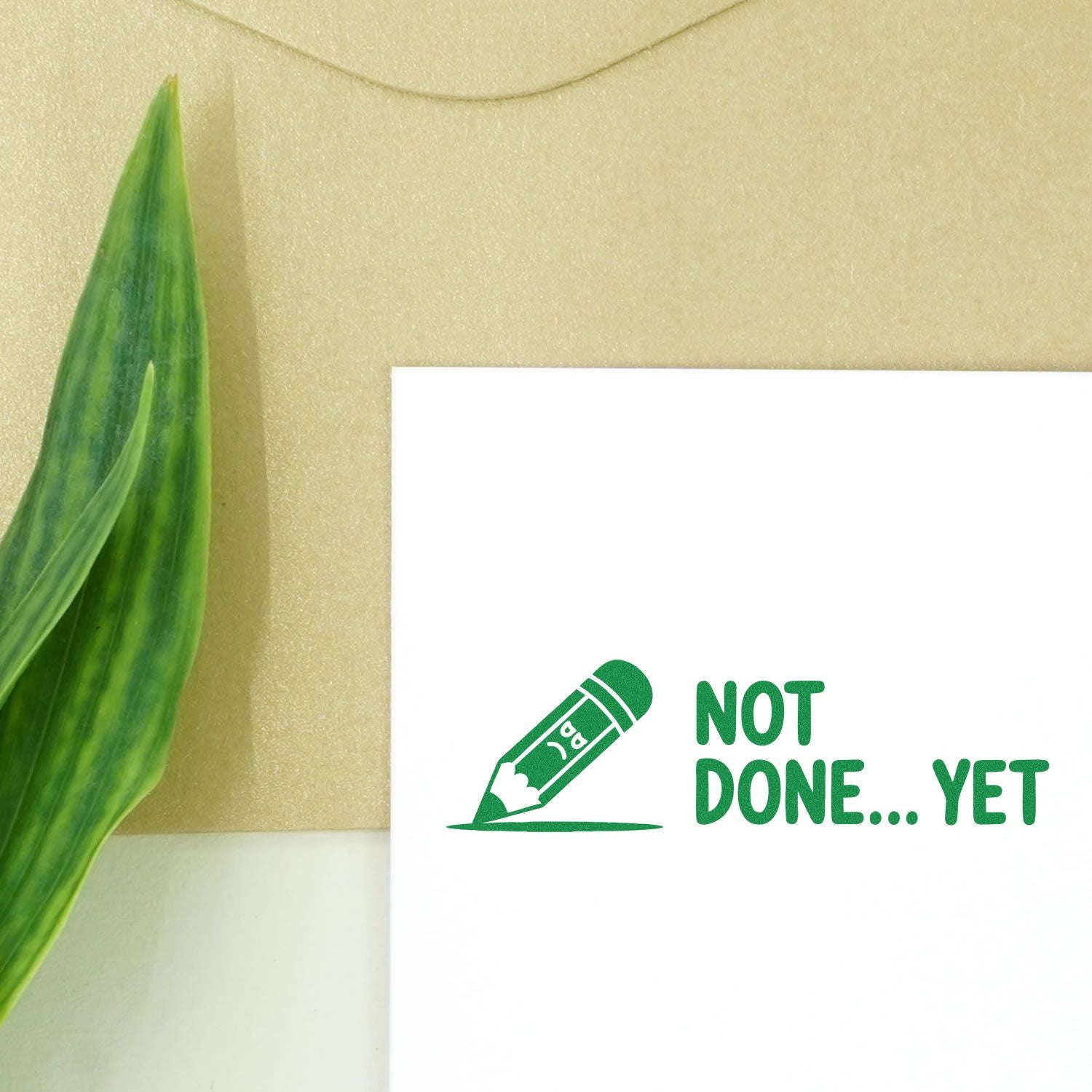 Green Not Done Yet rubber stamp with pencil icon on white paper for office, school, or craft project status marking.