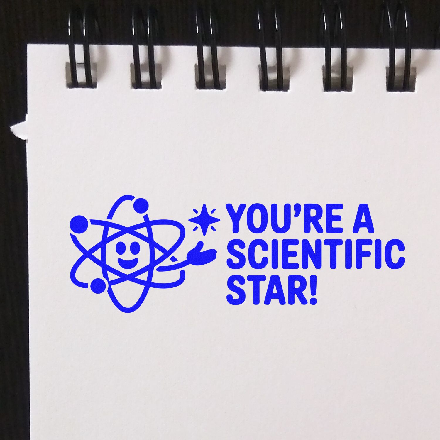 Blue rubber stamp design with atom icon and Youre a Scientific Star! text for science classroom rewards.