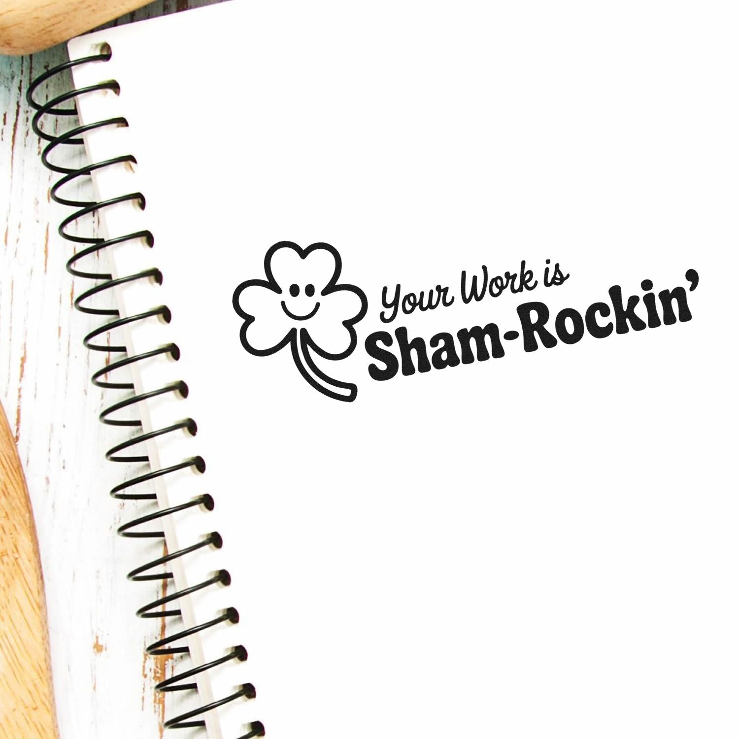 Shamrockin rubber stamp with smiling clover and Your Work is Sham-Rockin message on a notebook page.