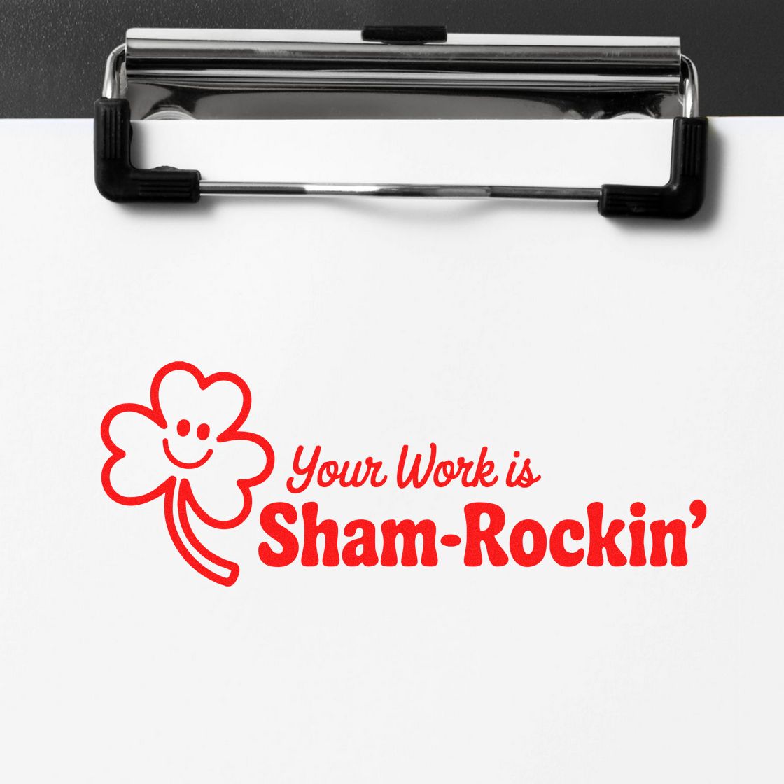 Custom rubber stamp impression with shamrock design and text, Your Work is Sham-Rockin, on a clipboard.