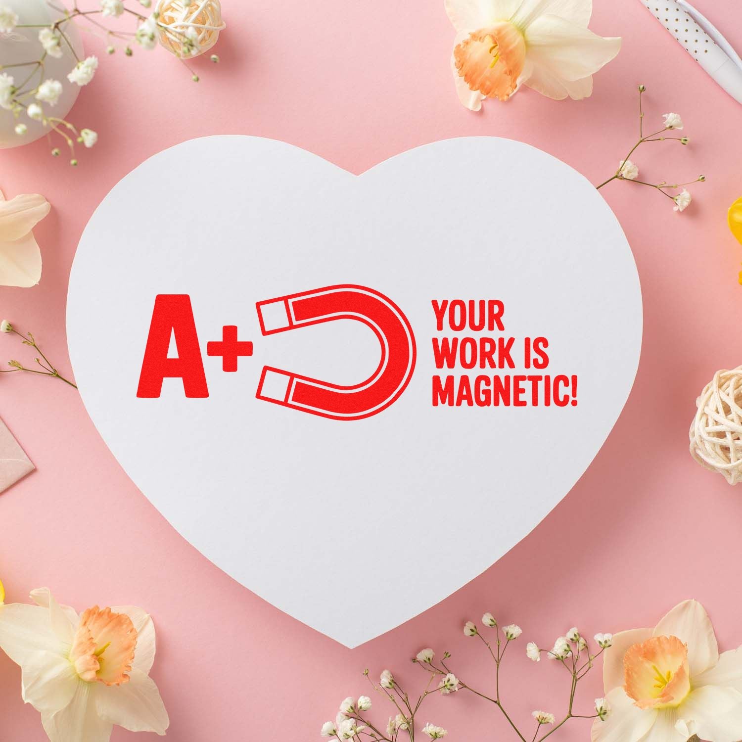 A+ Your Work Is Magnetic rubber stamp design on heart-shaped card with floral pink background