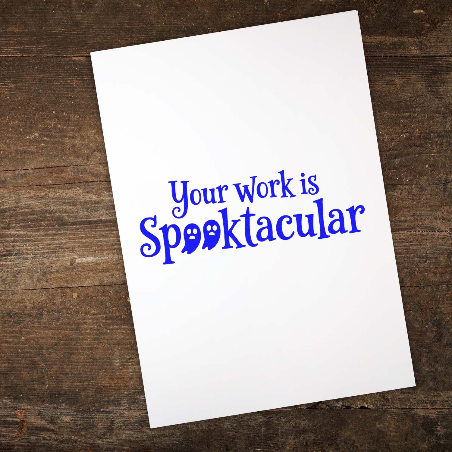 Halloween rubber stamp reading "Your work is Spooktacular" in blue ink on white card for crafts and teacher notes.