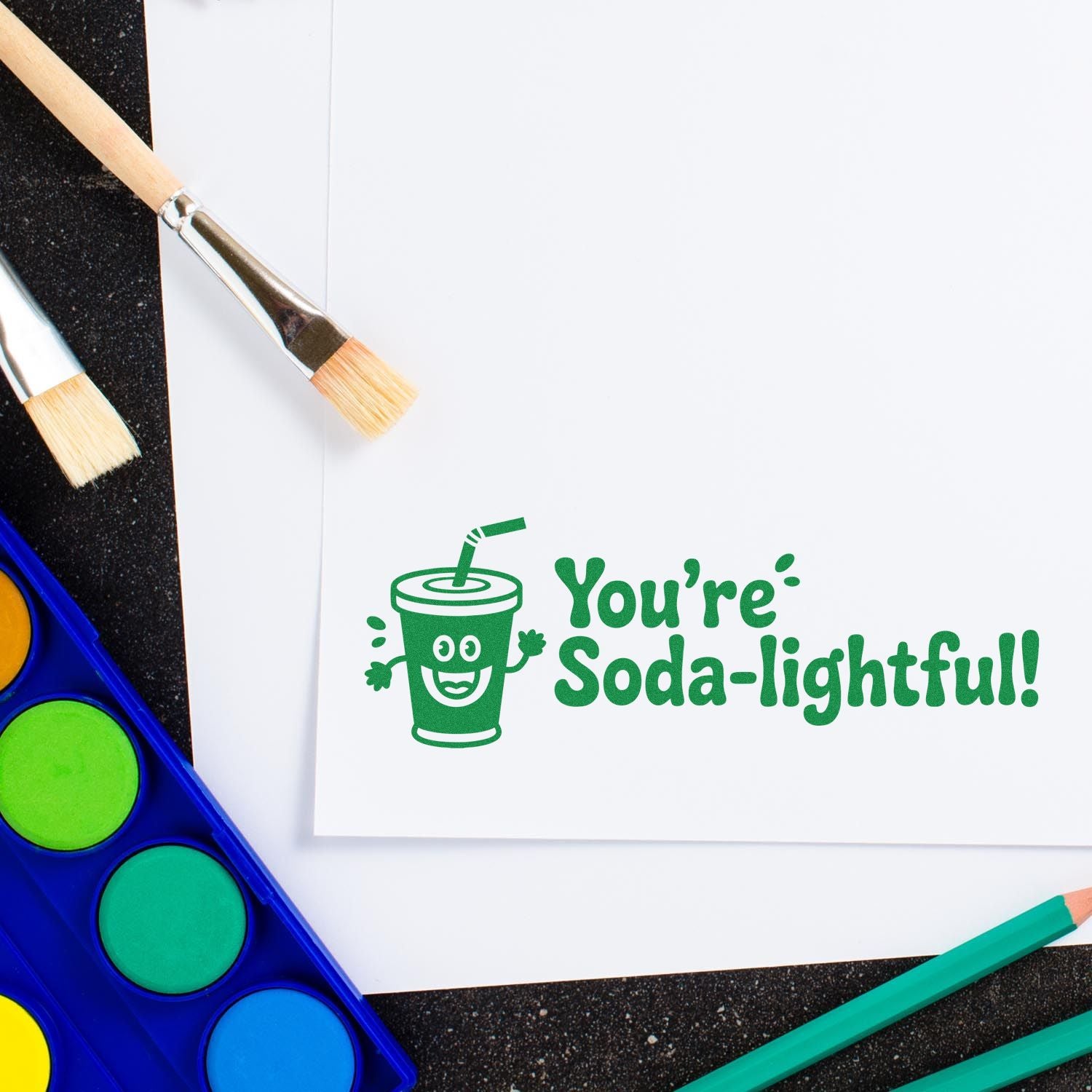 Green custom rubber stamp design with a smiling soda cup and Youre Soda-lightful! on paper for crafting and cardmaking.