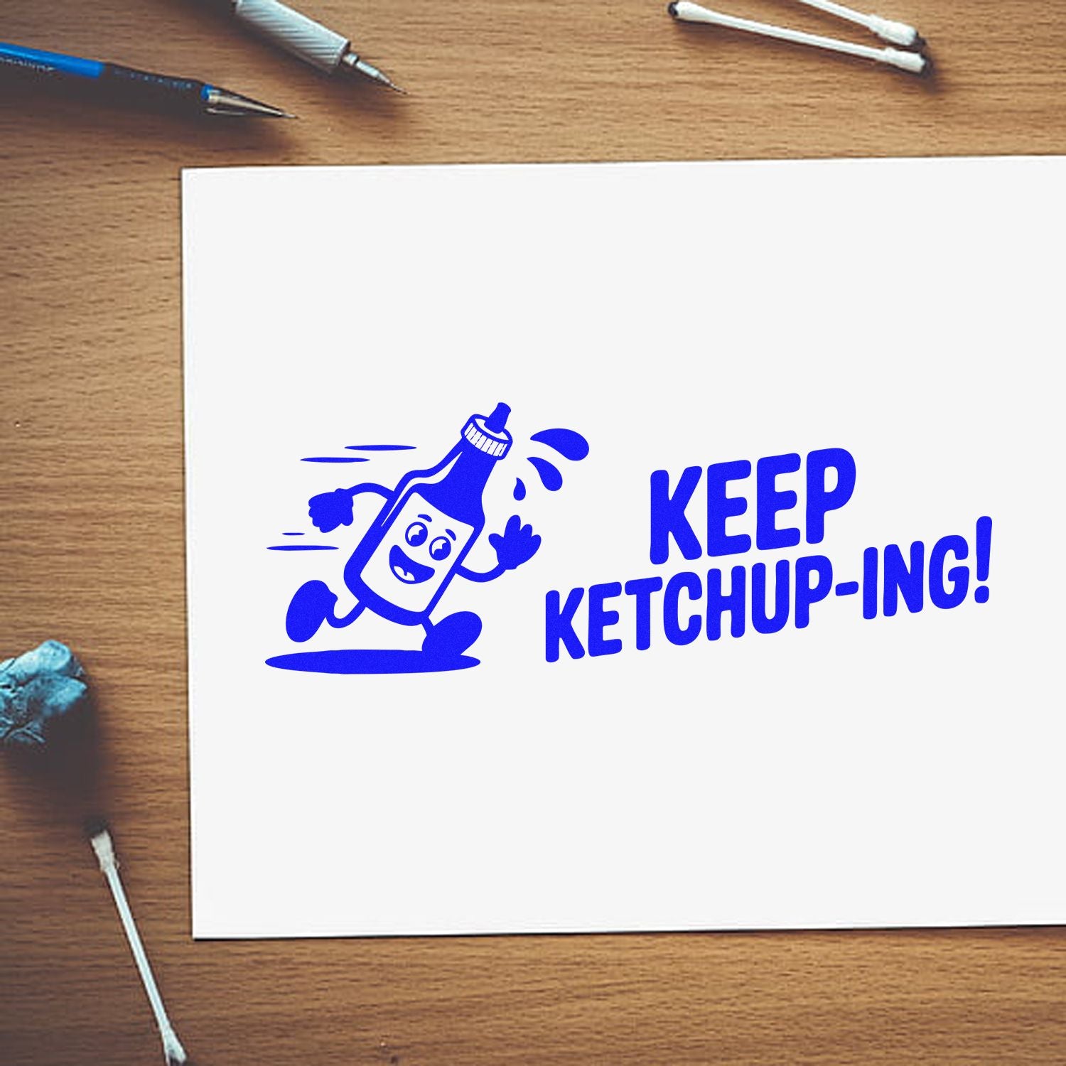 Funny ketchup rubber stamp design with running ketchup bottle and Keep Ketchup-ing! pun on white paper.