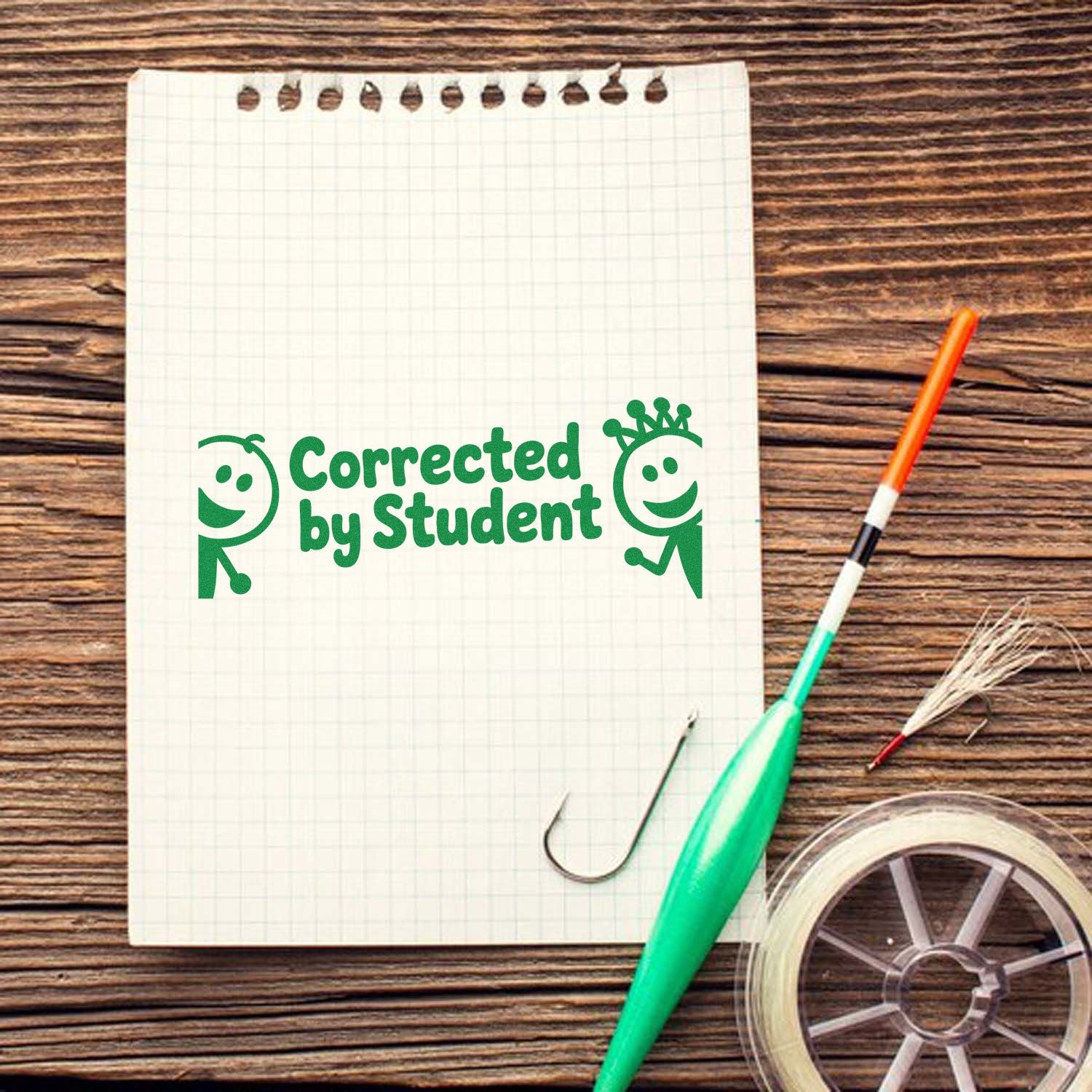 Rubber stamp design reading Corrected by Student for teacher feedback on notebooks and student homework.