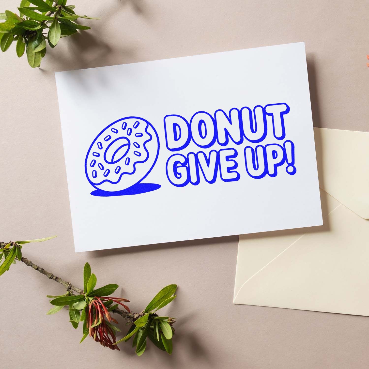 Custom rubber stamp mockup reading Donut Give Up with donut icon for playful stationery, packaging, and craft branding.
