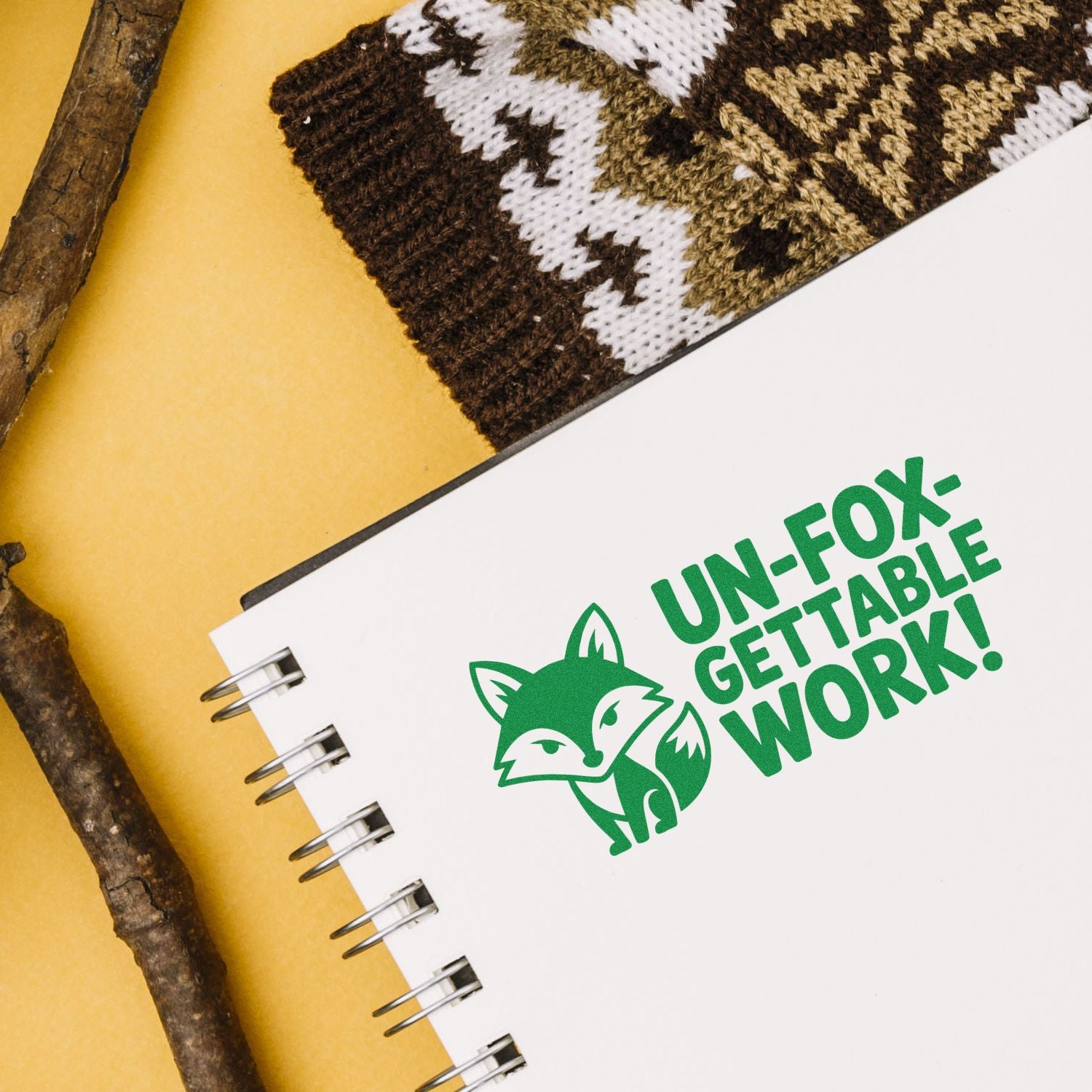 Un-fox-gettable Work fox logo rubber stamp on notebook, a fun eco-friendly branding design for office stationery.