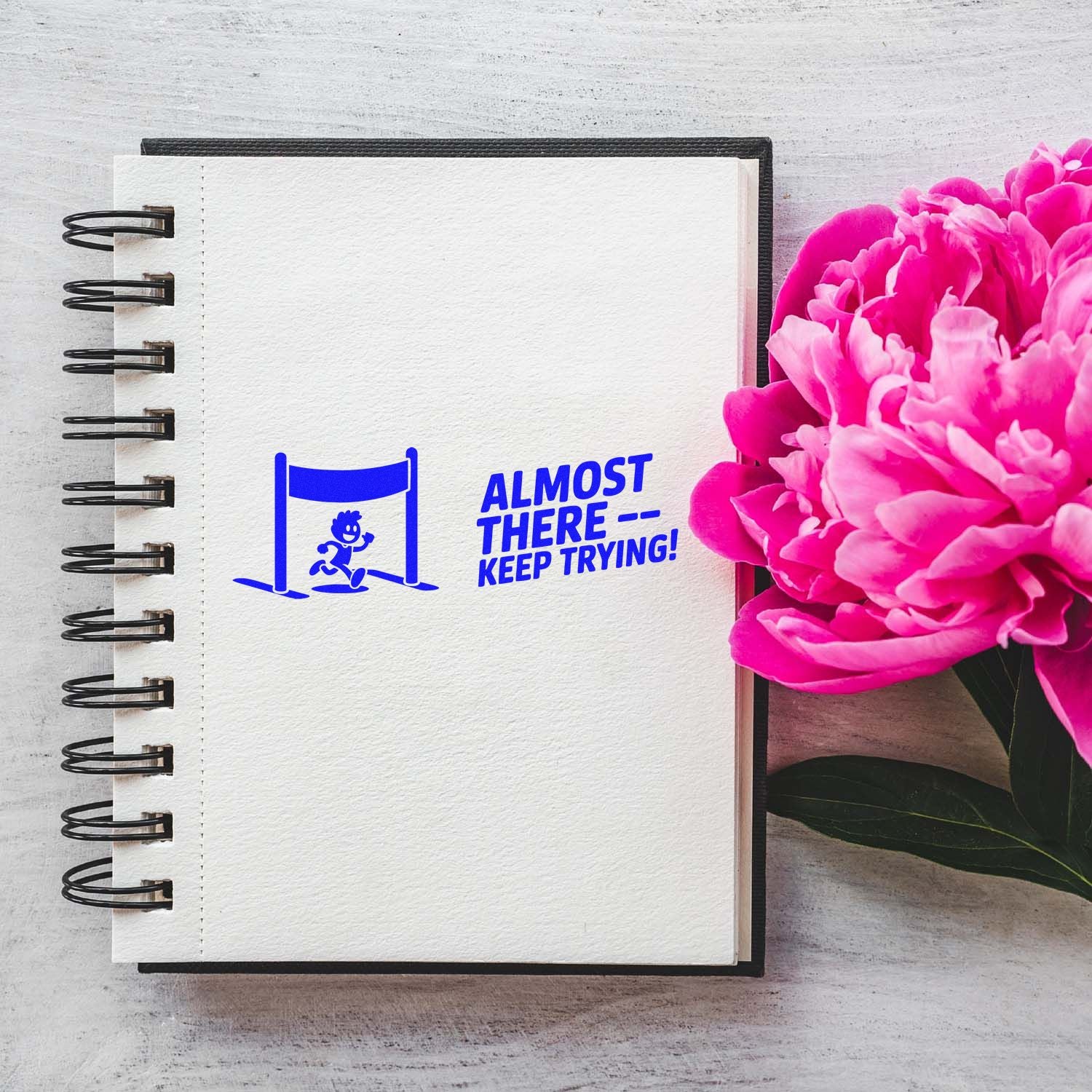 Motivational rubber stamp design with runner and Almost therekeep trying! text on notebook page