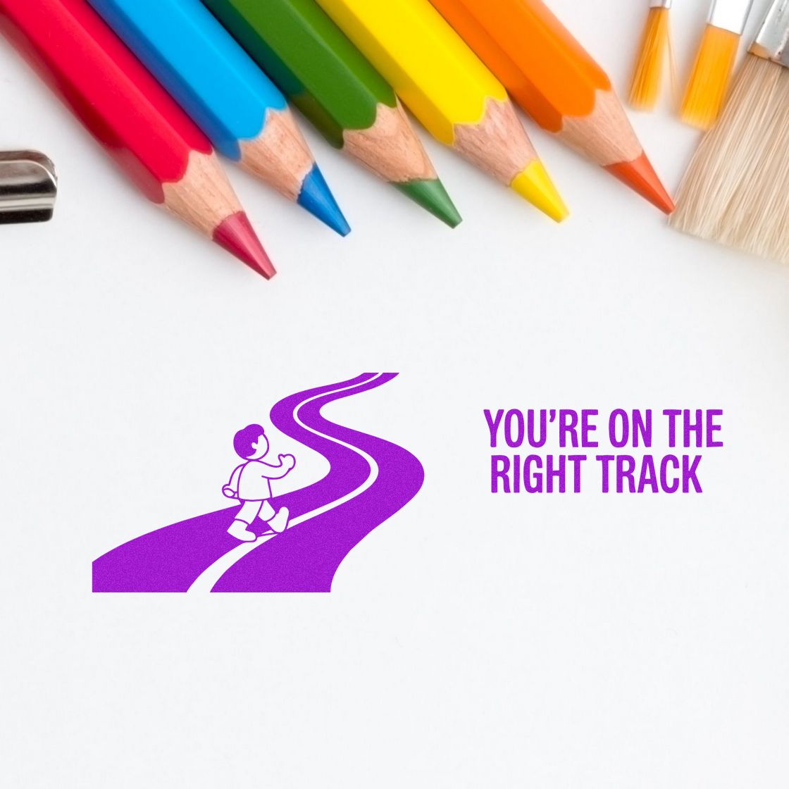 "You're on the right track" rubber stamp with road and child design, ideal for teacher encouragement and student work.