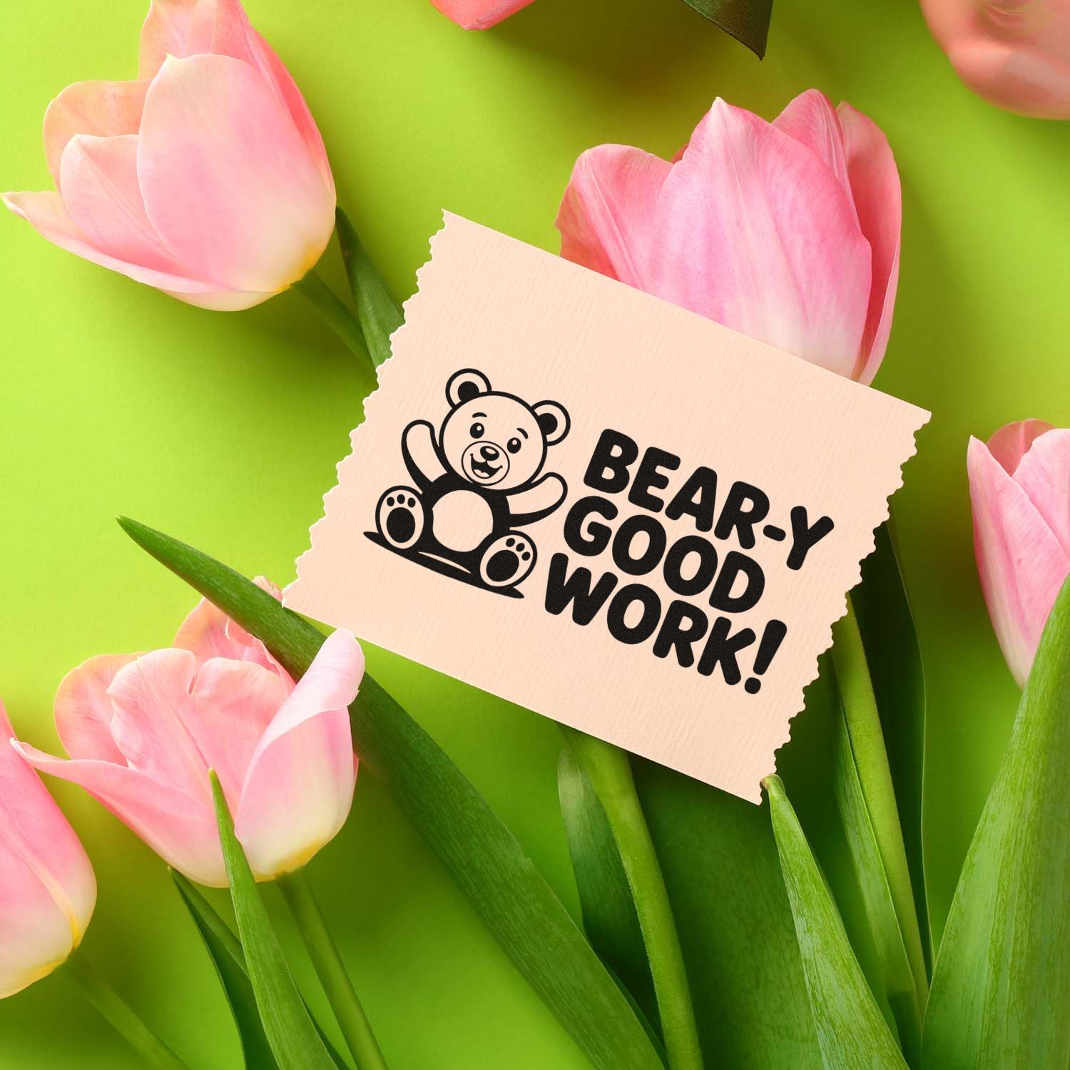 Custom rubber stamp design with cute teddy bear and Bear-y Good Work! message, displayed among pink tulips.
