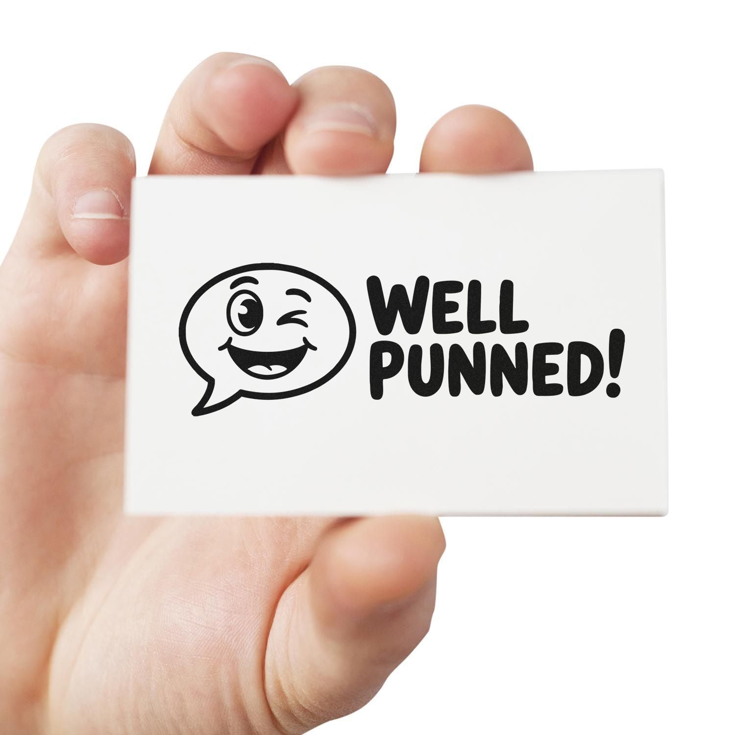 Hand holding a Well Punned rubber stamp with winking face, ideal for funny custom stamp impressions and office humor.
