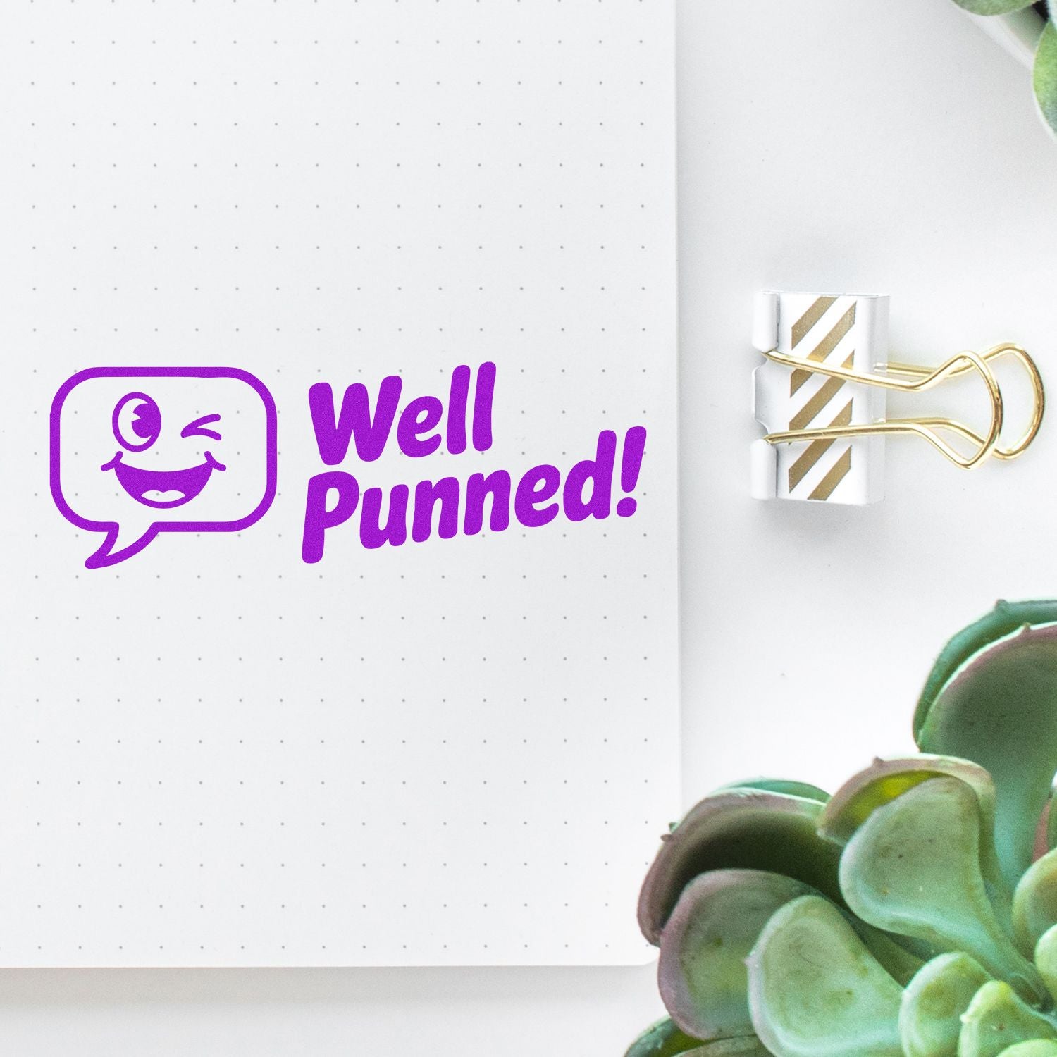 Humorous purple rubber stamp reading Well Punned! on a dotted notebook page, perfect for journaling, planners, and office crafts.