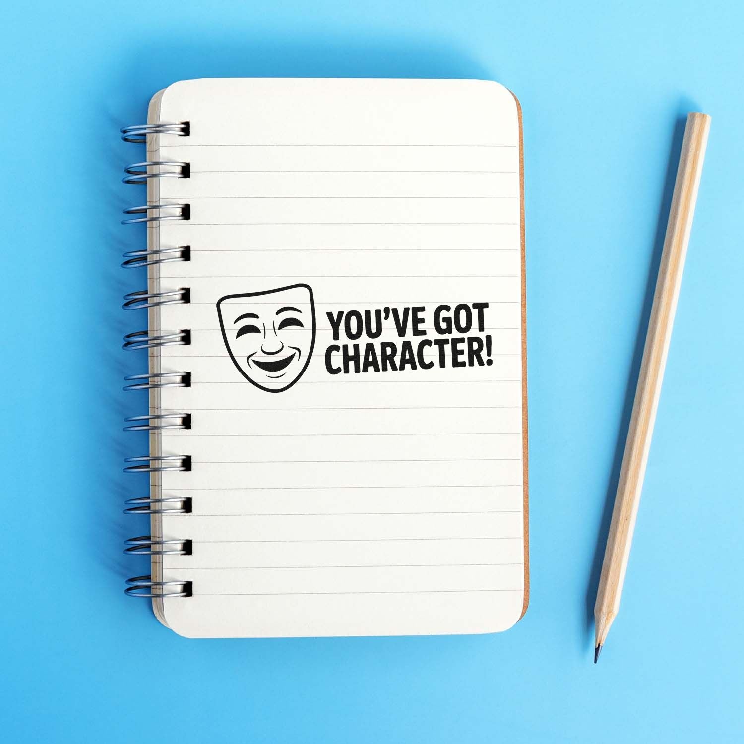 Rubber stamp design reading Youve Got Character! with theater mask icon on a notebook, ideal for teacher reward stamps.