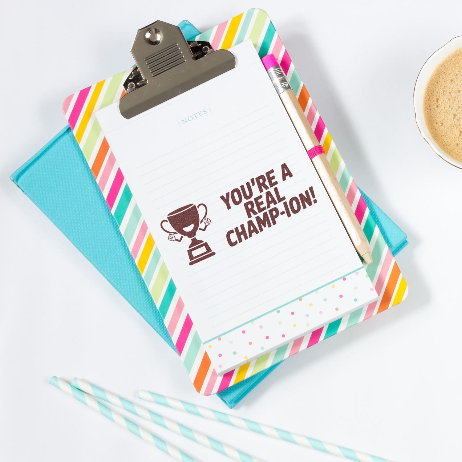 Motivational rubber stamp saying Youre a real champ-ion! on notepad clipboard, ideal for teacher or office rewards.