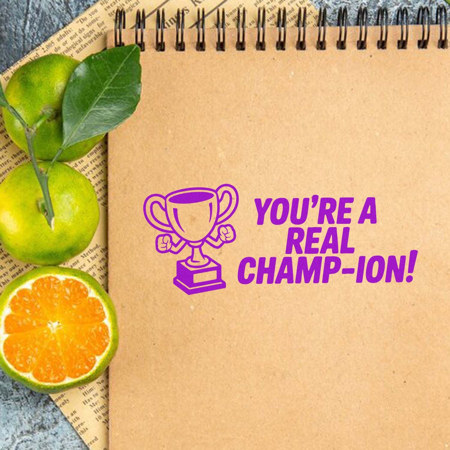 Custom rubber stamp design with trophy and Youre a real champion! for award cards, teacher gifts, and celebration crafts.