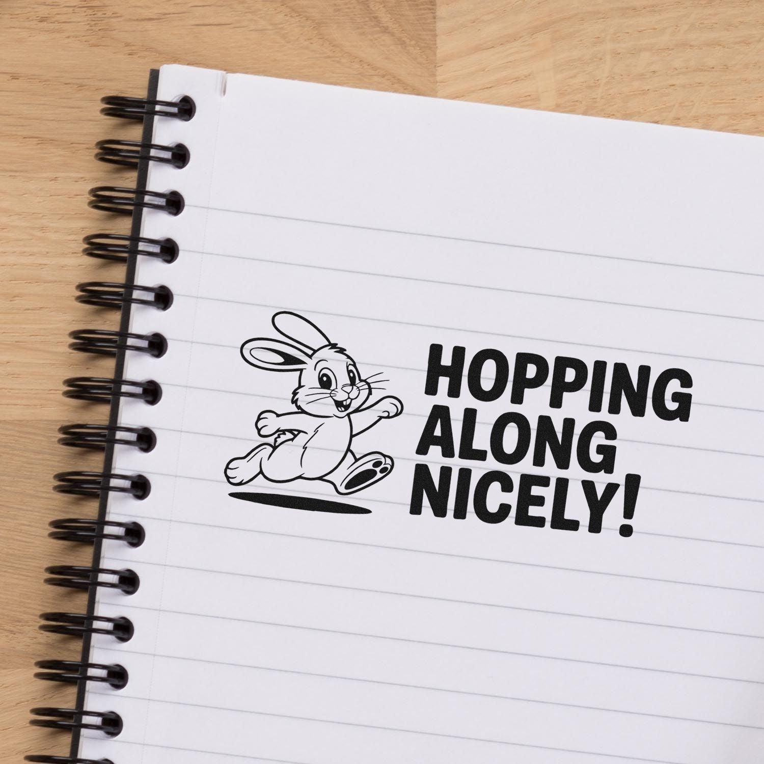Cute bunny rubber stamp with Hopping Along Nicely! on lined notebook paper