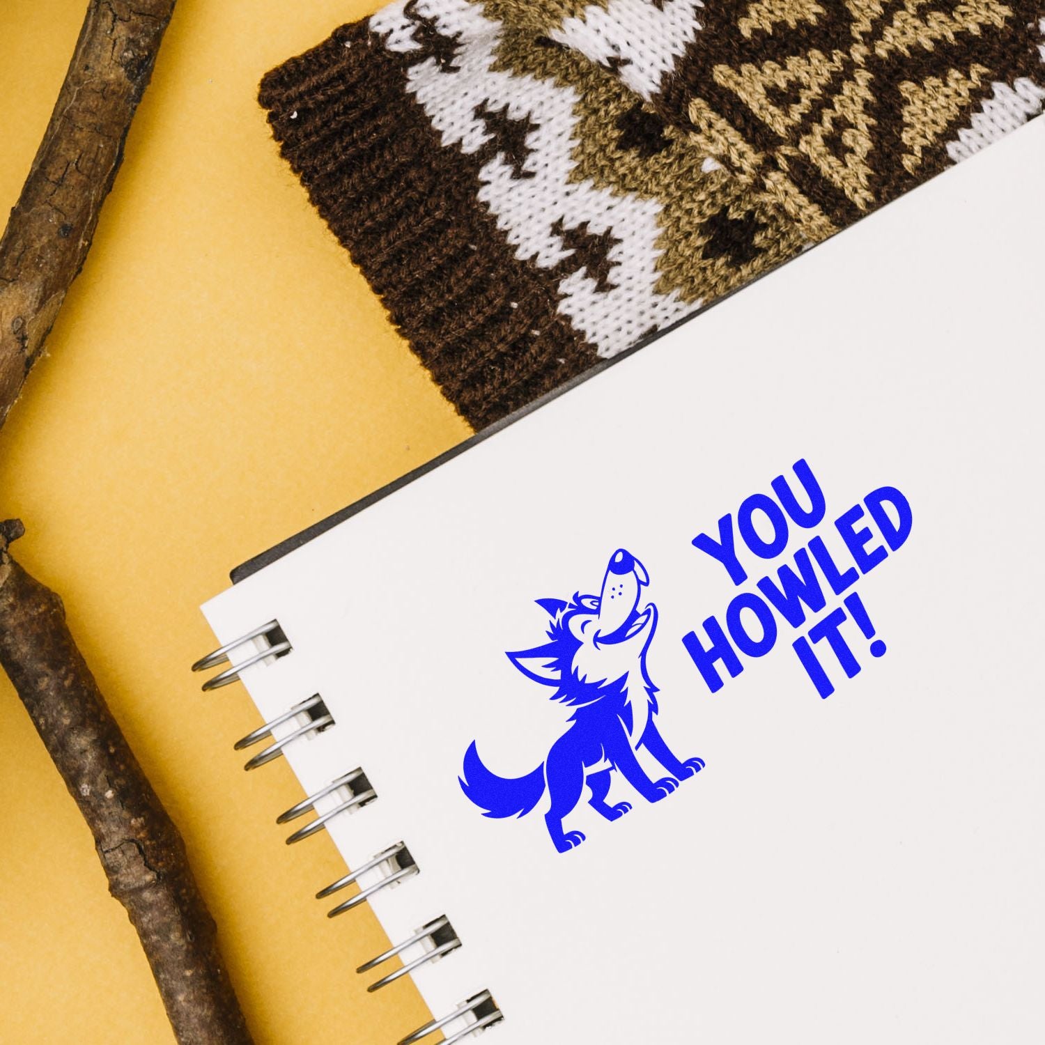 Custom rubber stamp with wolf graphic and You Howled It! on a notebook, ideal for playful branding and craft projects