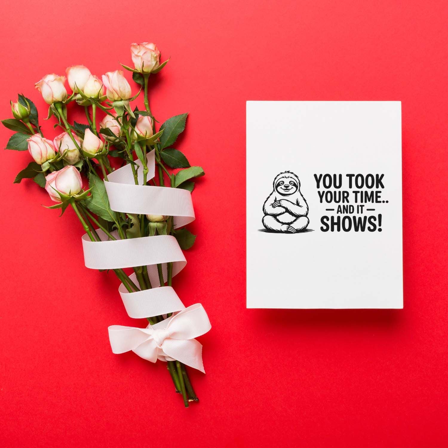Funny rubber stamp card with sloth and You took your time...and it shows! beside ribbon-wrapped roses on a red background.