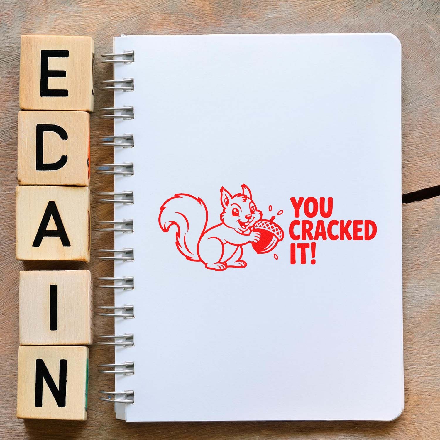 Squirrel rubber stamp with You Cracked It! message, stamped in red on a notebook for teacher rewards and craft projects.