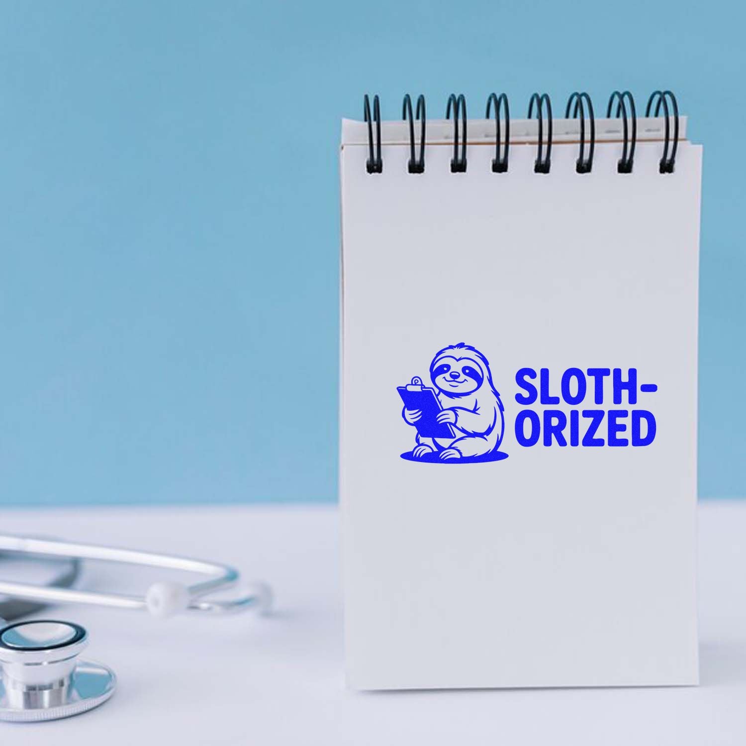 Blue sloth-ORIZED rubber stamp on a notepad, featuring a sloth illustration for fun custom office branding.