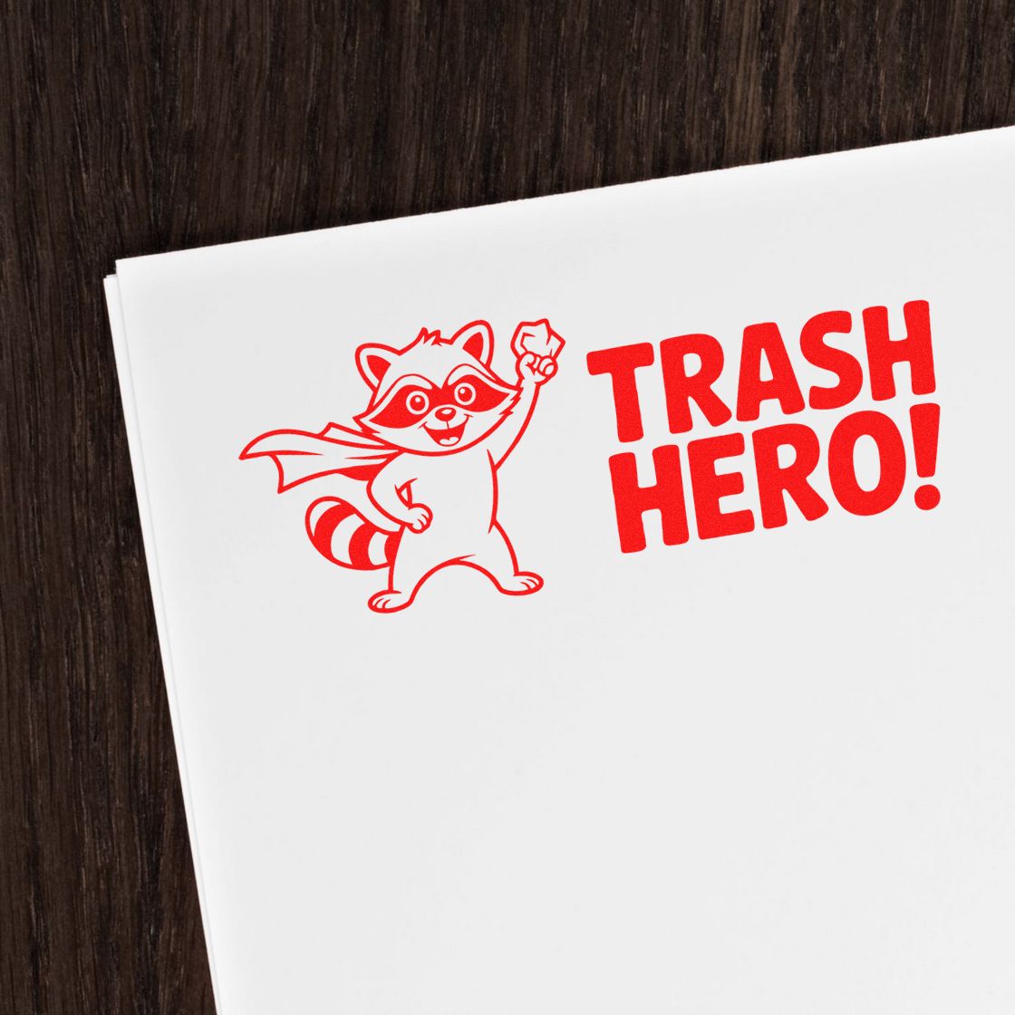 Red Trash Hero raccoon rubber stamp design on white paper, ideal for recycling, waste cleanup, and eco-friendly branding.
