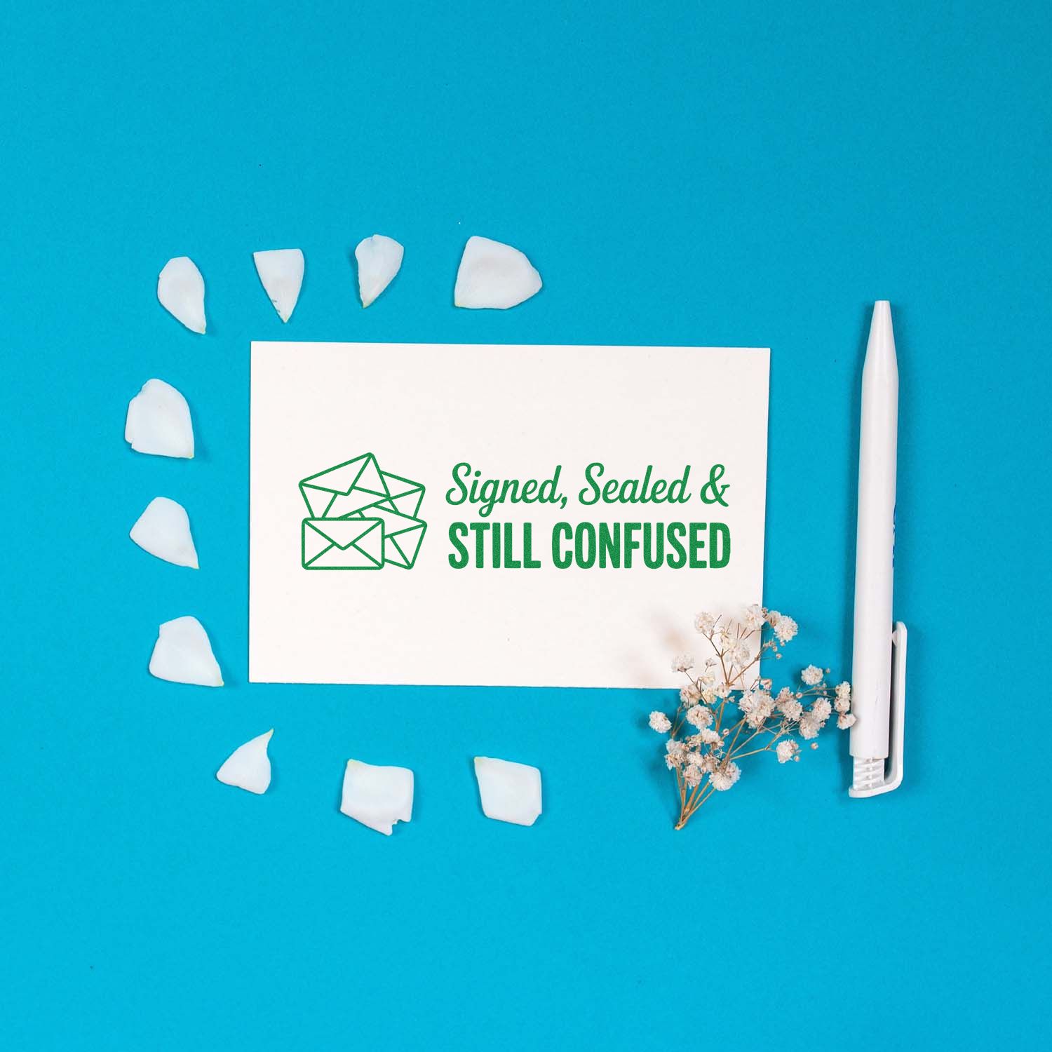 Custom rubber stamp with Signed, Sealed & Still Confused design, featuring an envelope icon on a styled stationery flat lay.